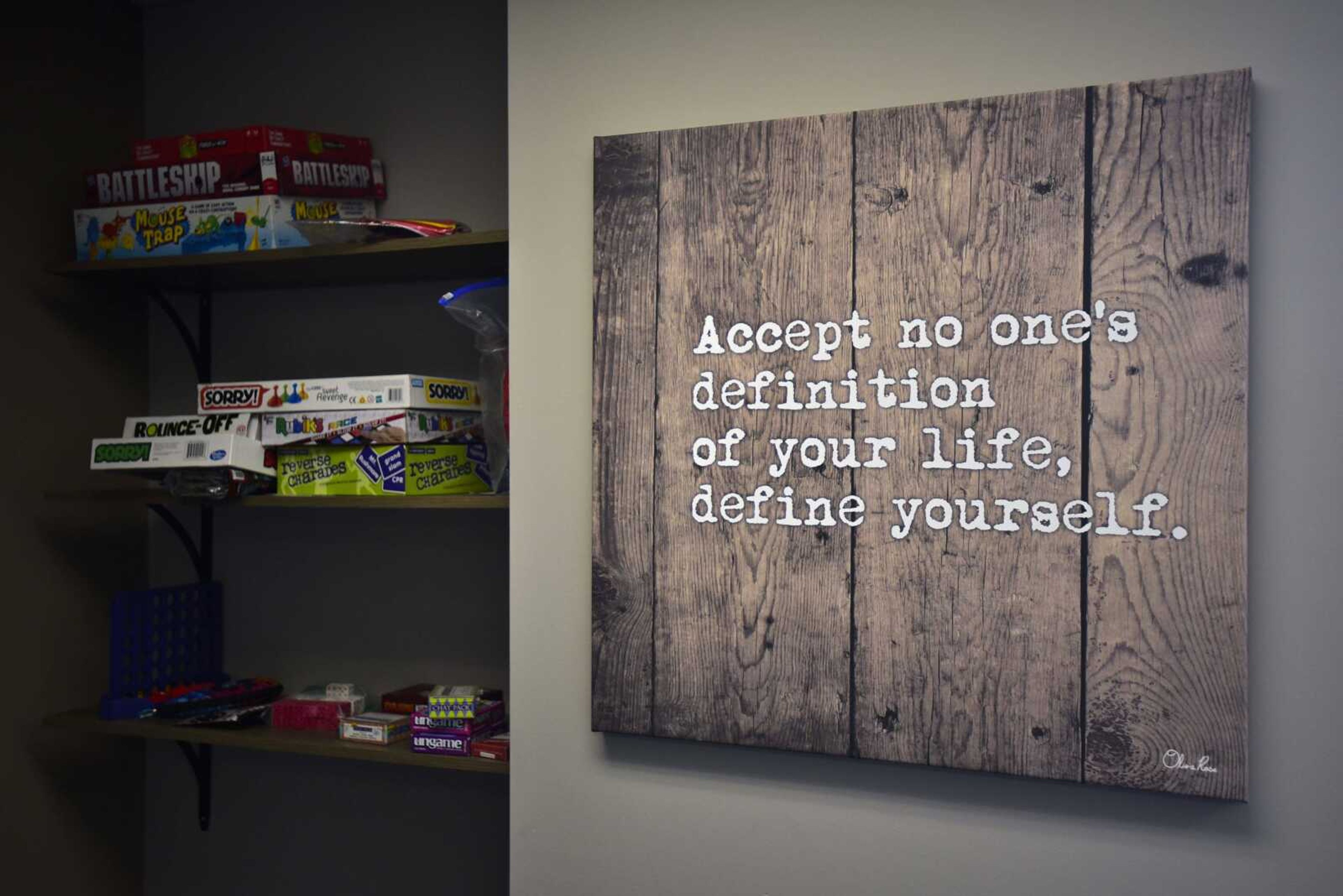 An inspirational quote hangs next to a shelf of board games Thursday at the Morning Star office in Cape Girardeau.