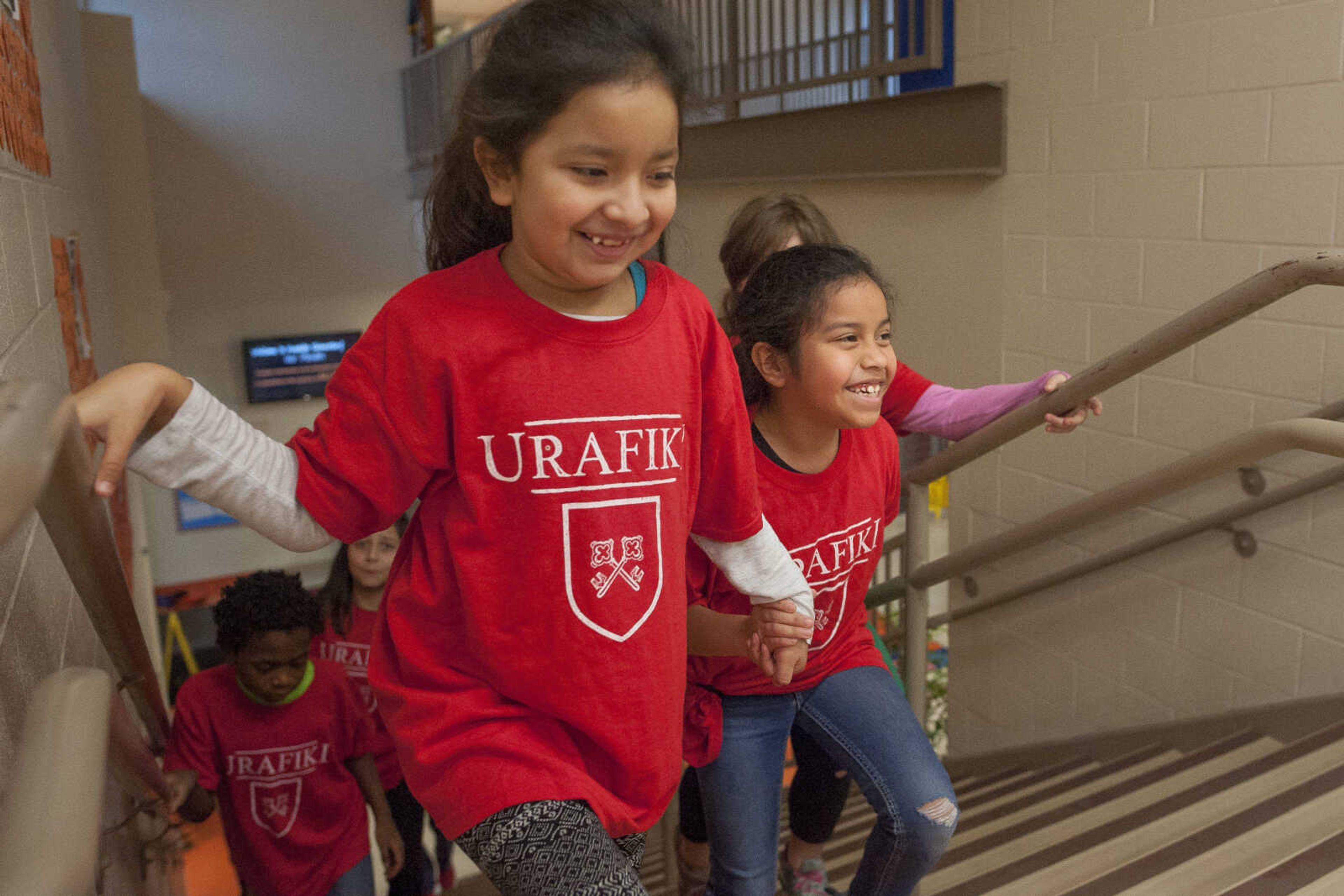 Grethel Padilla, left, and Johana Salinas-Garcia ascend a set of stairs hand-in-hand before a celebratory assembly for the four "houses" of the student body Friday, Jan. 10, 2020, at Franklin Elementary in Cape Girardeau.