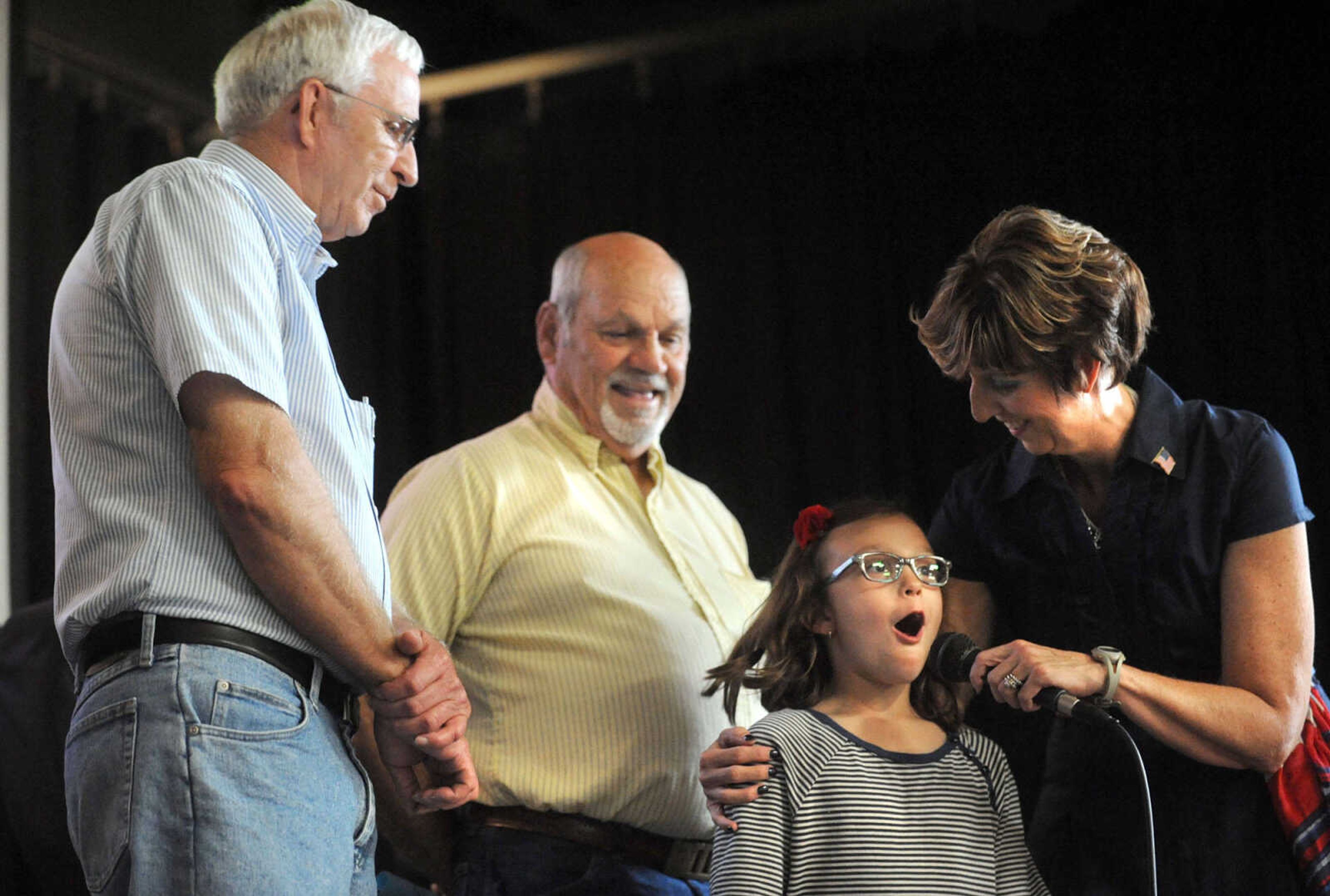 LAURA SIMON ~ lsimon@semissourian.com

Alma Schrader second-grade student Anne McDougal turns back to principal Ruth Ann Orr and the microphone after a reminder of the branches of service her grandfathers, Army veteran Dean McDougal, left, and Navy veteran Larry Reed served, Wednesday, Sept. 18, 2013, during 12th annual Constitution Day and Heroes Recognition Assembly at the elementary school. Students were invited to bring their heroes to introduce to the school during the celebration.