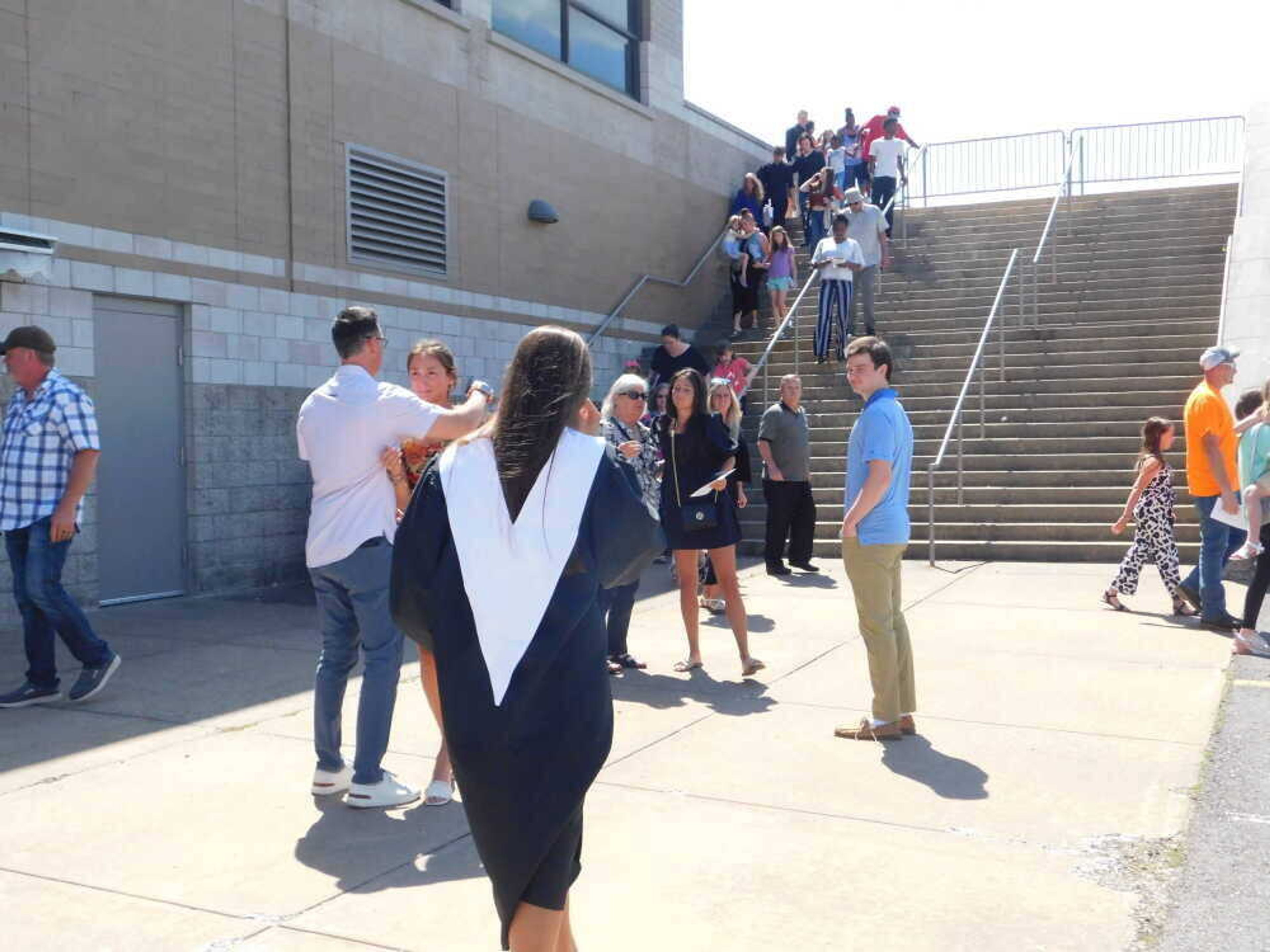 Attendees console one another and file out of the Show Me Center on the campus of Southeast Missouri State University on Sunday, May 19. Two people sustained non-life-threatening injuries after one person fired one shot following an altercation inside the venue during Cape Girardeau Central High School's graduation ceremony.