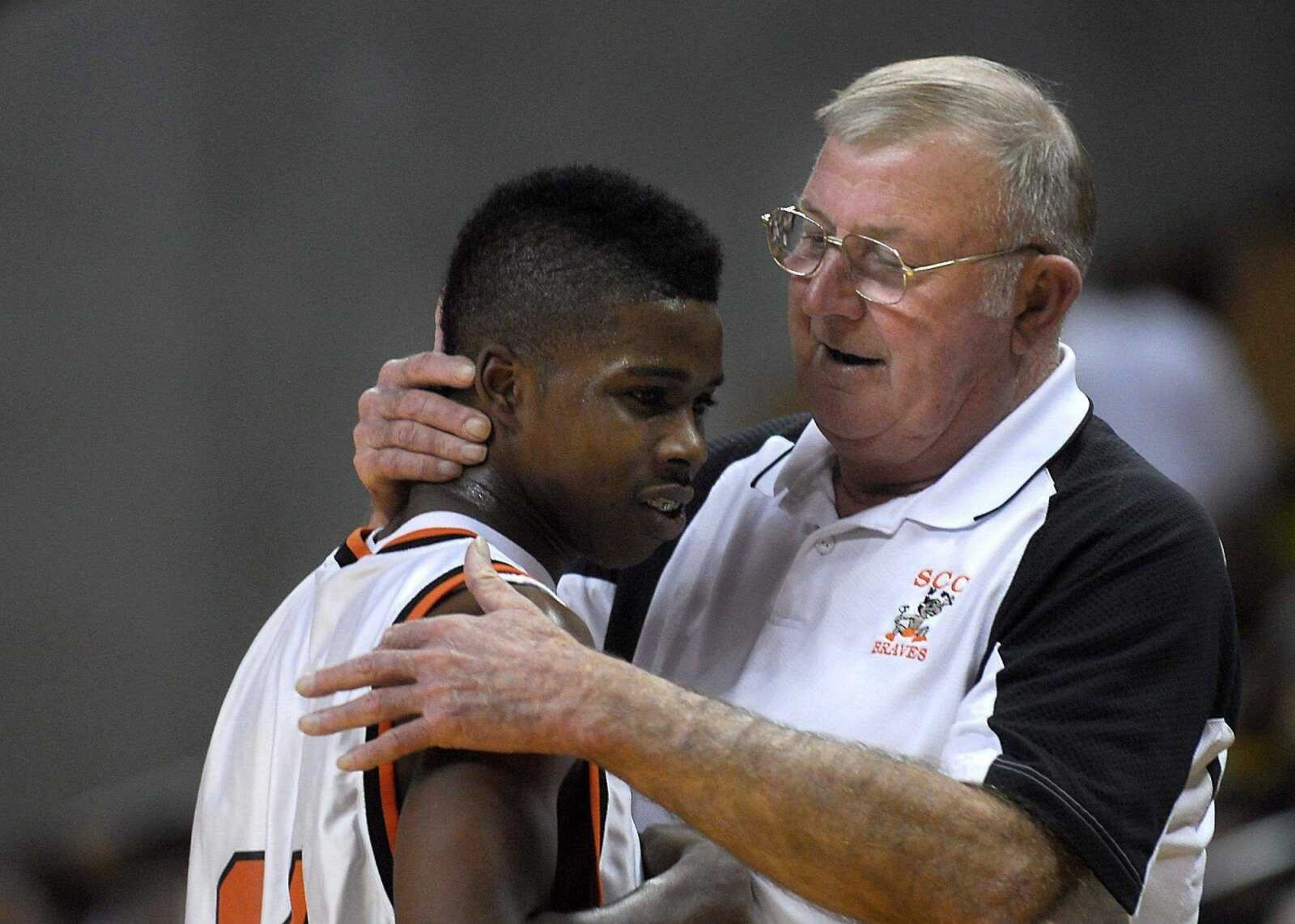 Scott County Central coach Ronnie Cookson congratulates Braves guard Bobby Hatchett during the final minutes of Friday's victory.