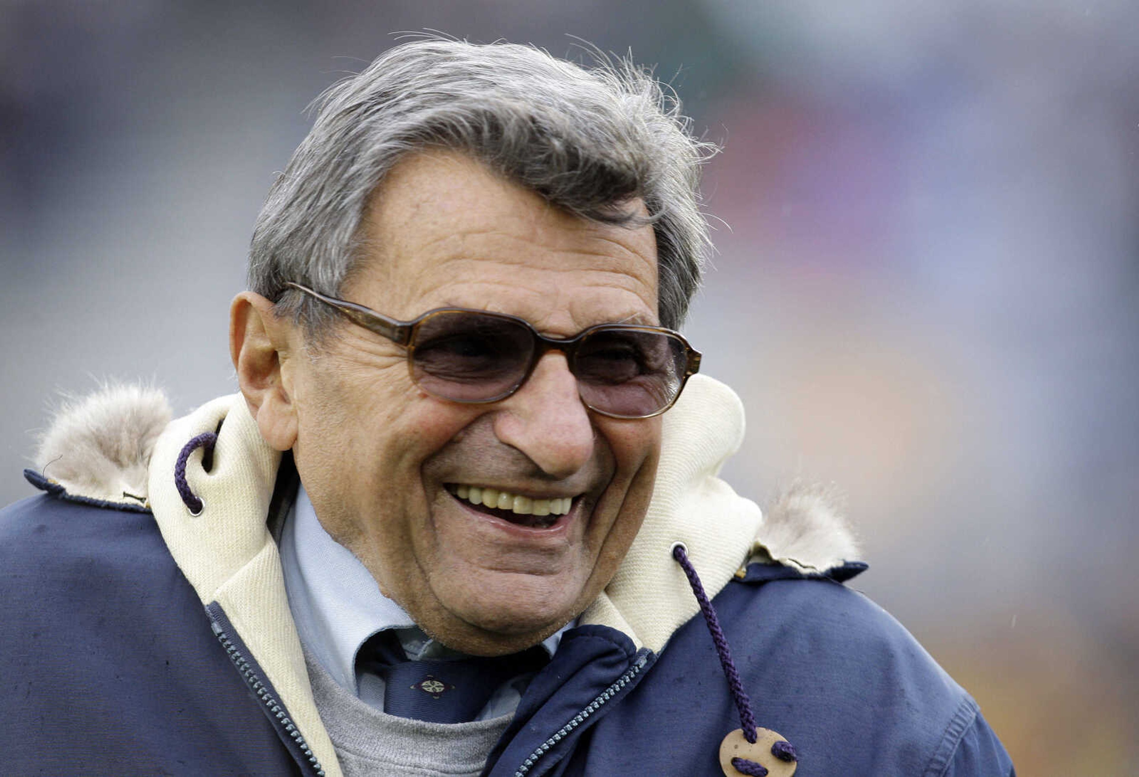 FILE - In this Oct. 17, 2009 file photo, Penn State coach Joe Paterno smiles as he walks the field before an NCAA college football game against Minnesota in State College, Pa. On Sunday, Jan. 22, 2012, family says Paterno, winningest coach in major college football, has died. (AP Photo/Carolyn Kaster, File)