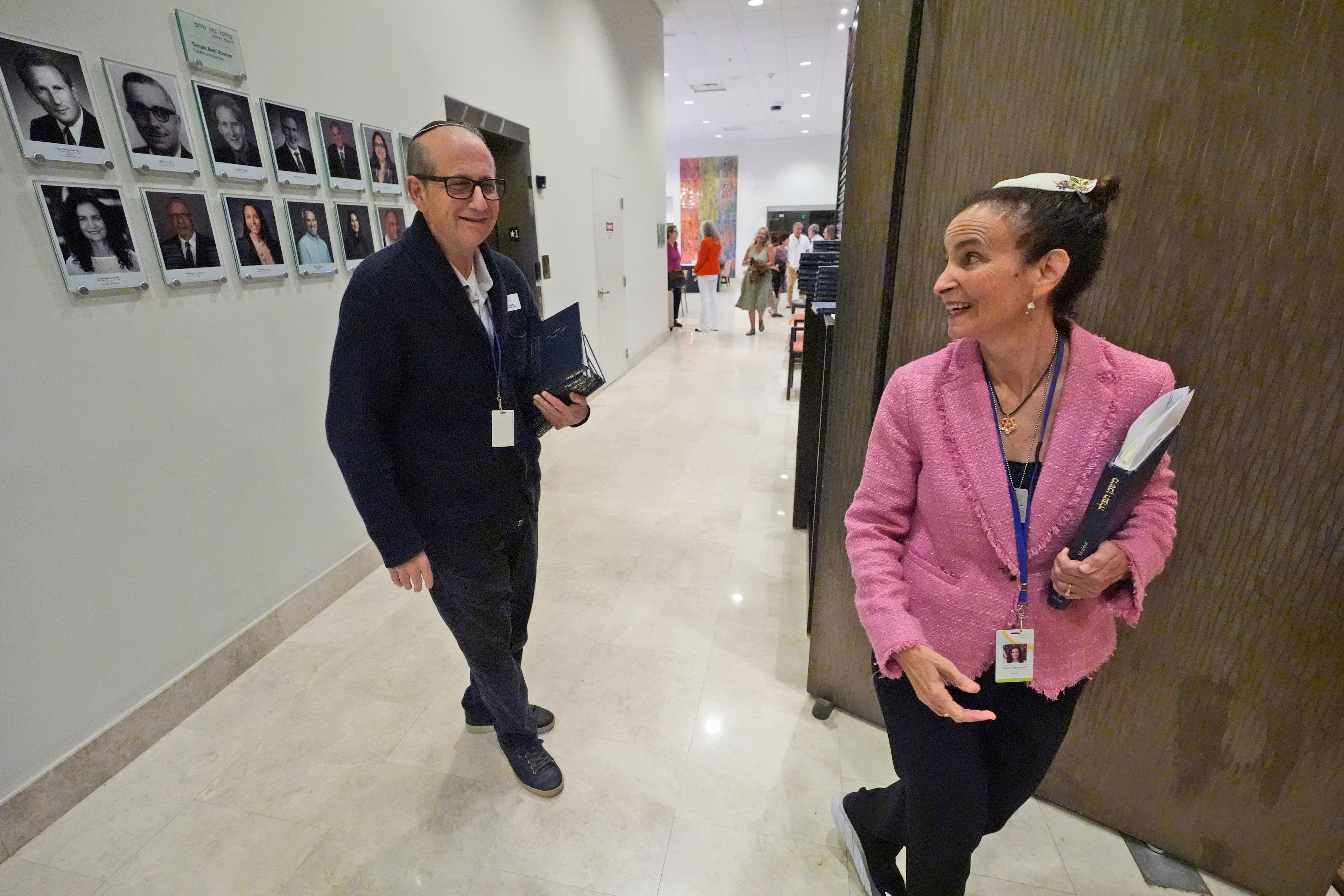 Craig Berko, left, director of membership at Temple Beth Sholom, chats with senior rabbi Gayle Pomerantz as she prepares to start a Shabbat service, Friday, Sept. 27, 2024, in Miami Beach, Fla. (AP Photo/Wilfredo Lee)