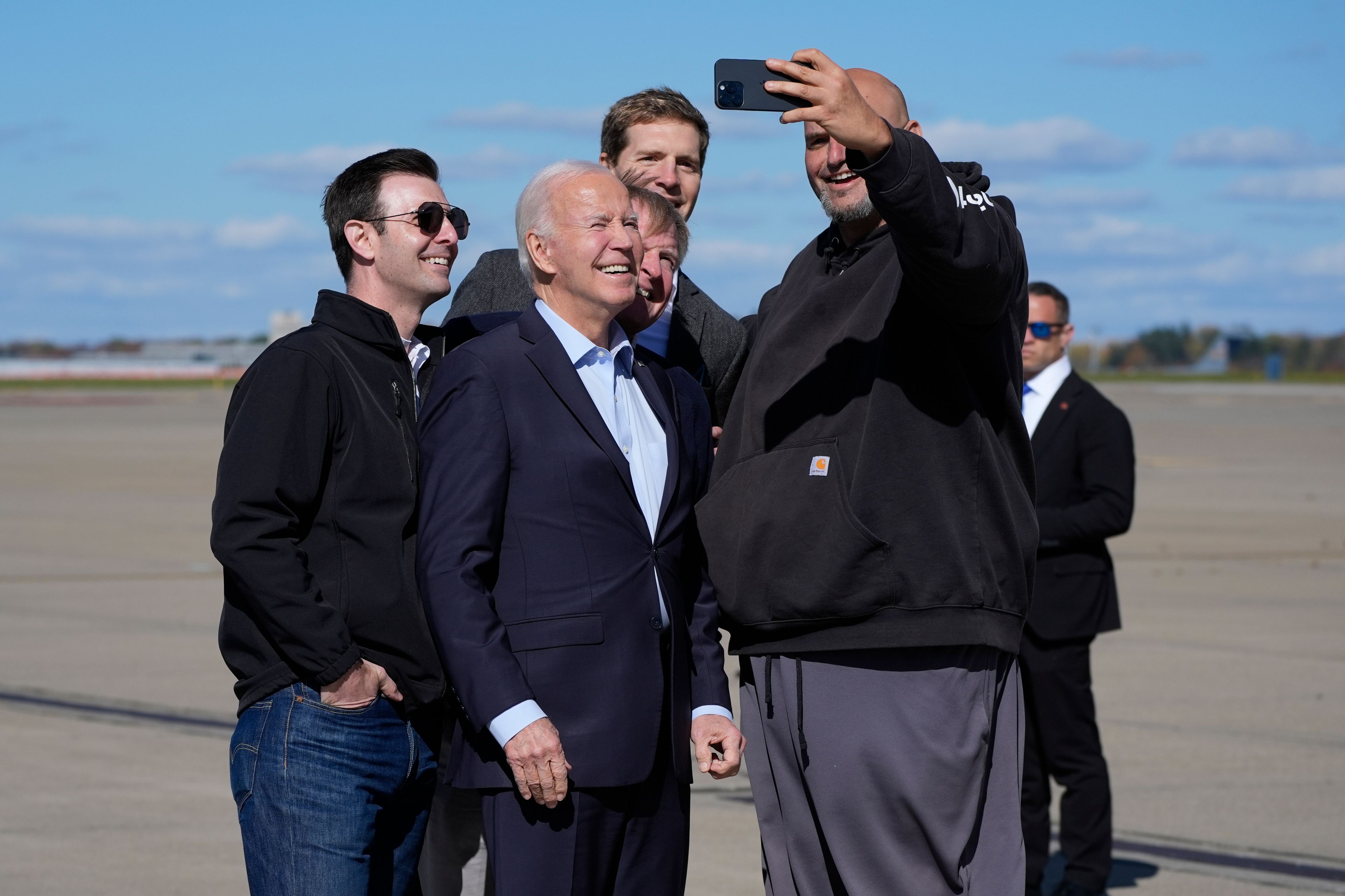 President Joe Biden, center, takes a selfie with Sen. John Fetterman, D-Pa., right, upon arriving at Pittsburgh International Airport in Pittsburgh, Saturday, Oct. 26, 2024, to attend a campaign event. (AP Photo/Manuel Balce Ceneta)