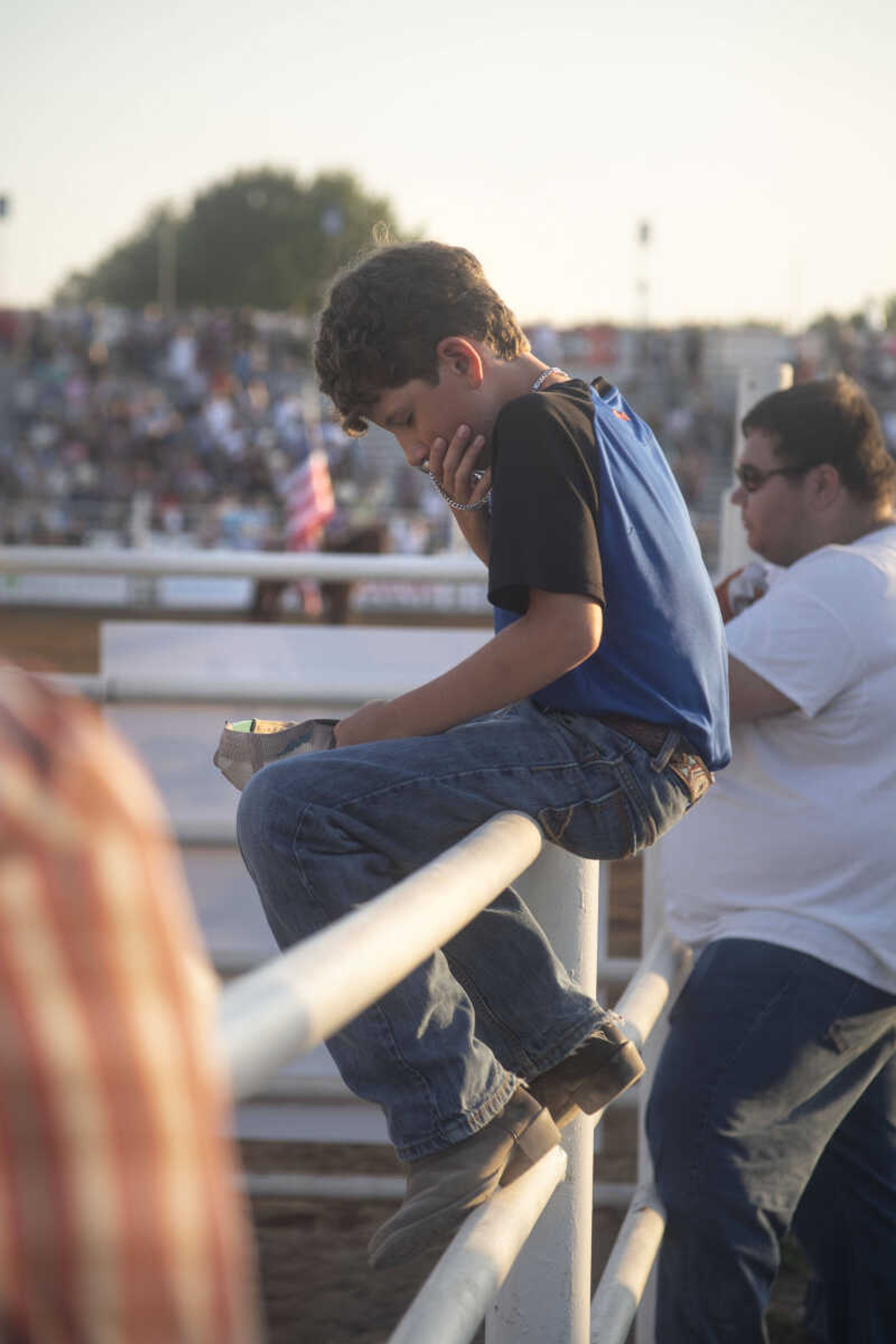 Eleven-year-old Blaze Tibbs kisses a crucifix during a prayer before the beginning of the Sikeston Jaycee Bootheel Rodeo on Thursday, Aug. 12, 2021, in Sikeston, Missouri.