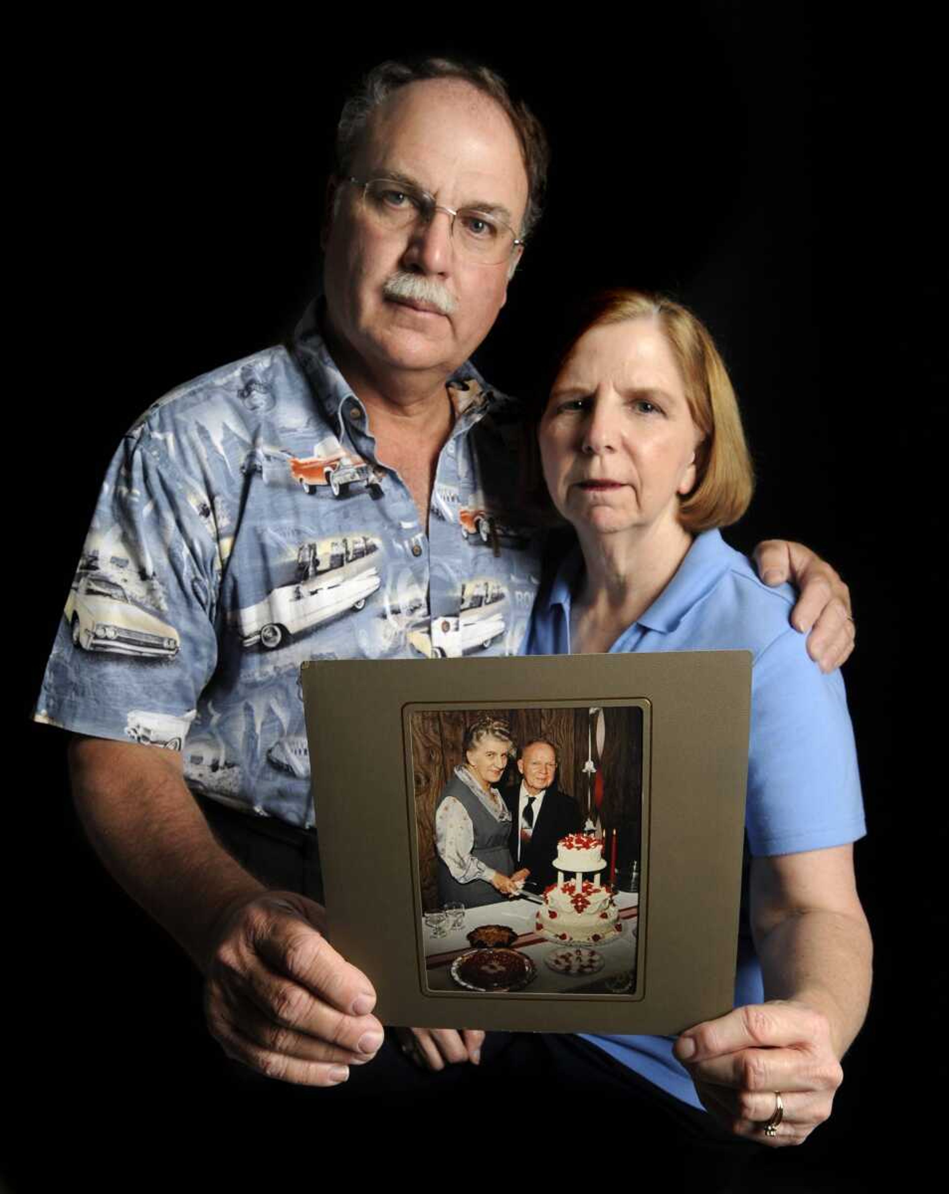 Pat and Edna Patterson with a picture of Pat's parents. Pat and Edna cared for his mother, Julia, and his father, Amos, both of whom suffered from dementia-related illnesses. (Fred Lynch)