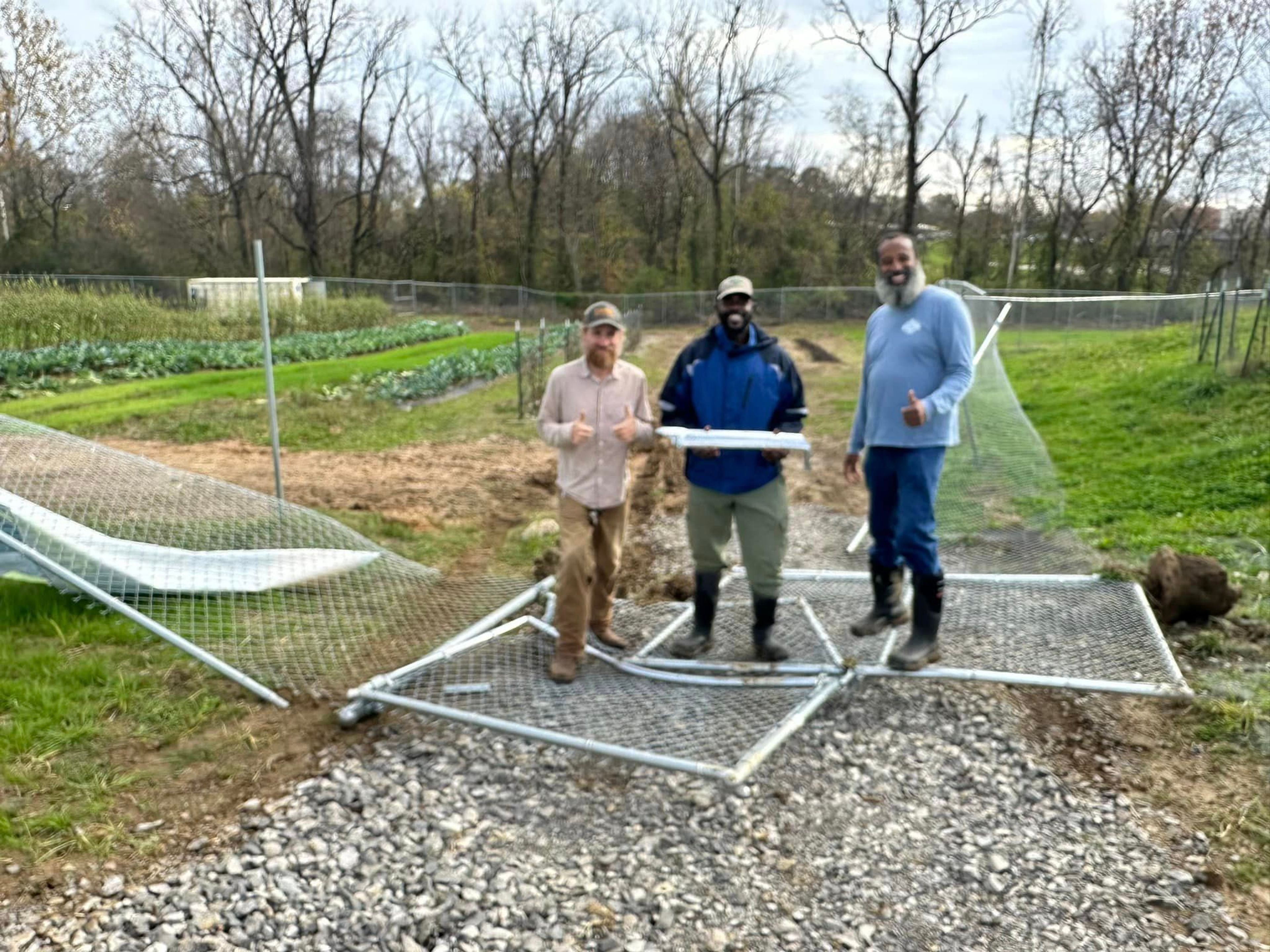 South Side Farms workers, from left, Jake Smith, Wyky Jean and Maurice Theriot stand amidst a damaged fence following a break-in at the farm that led to a truck being stolen. They were able to successfully host a farm stand without it and the truck was recovered two days after being reported stolen.