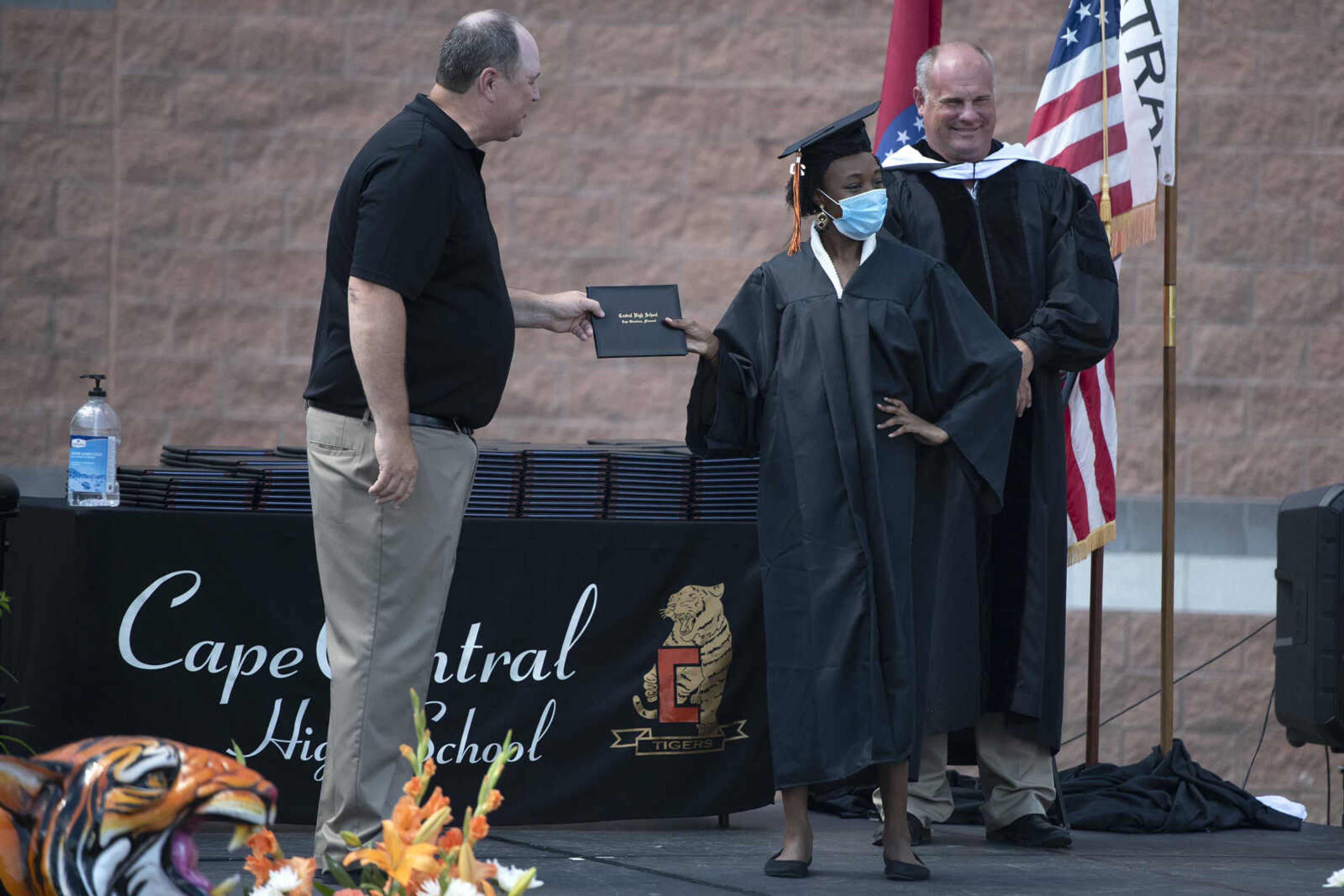 Graduate Taviunna Allen has pictures made with Jeff Glenn, former board of directors president for the Cape Girardeau School District (left), and Cape Girardeau School District superintendent Neil Glass (right) during a drive-through graduation ceremony Saturday, June 13, 2020, at Cape Girardeau Central High School in Cape Girardeau.&nbsp;