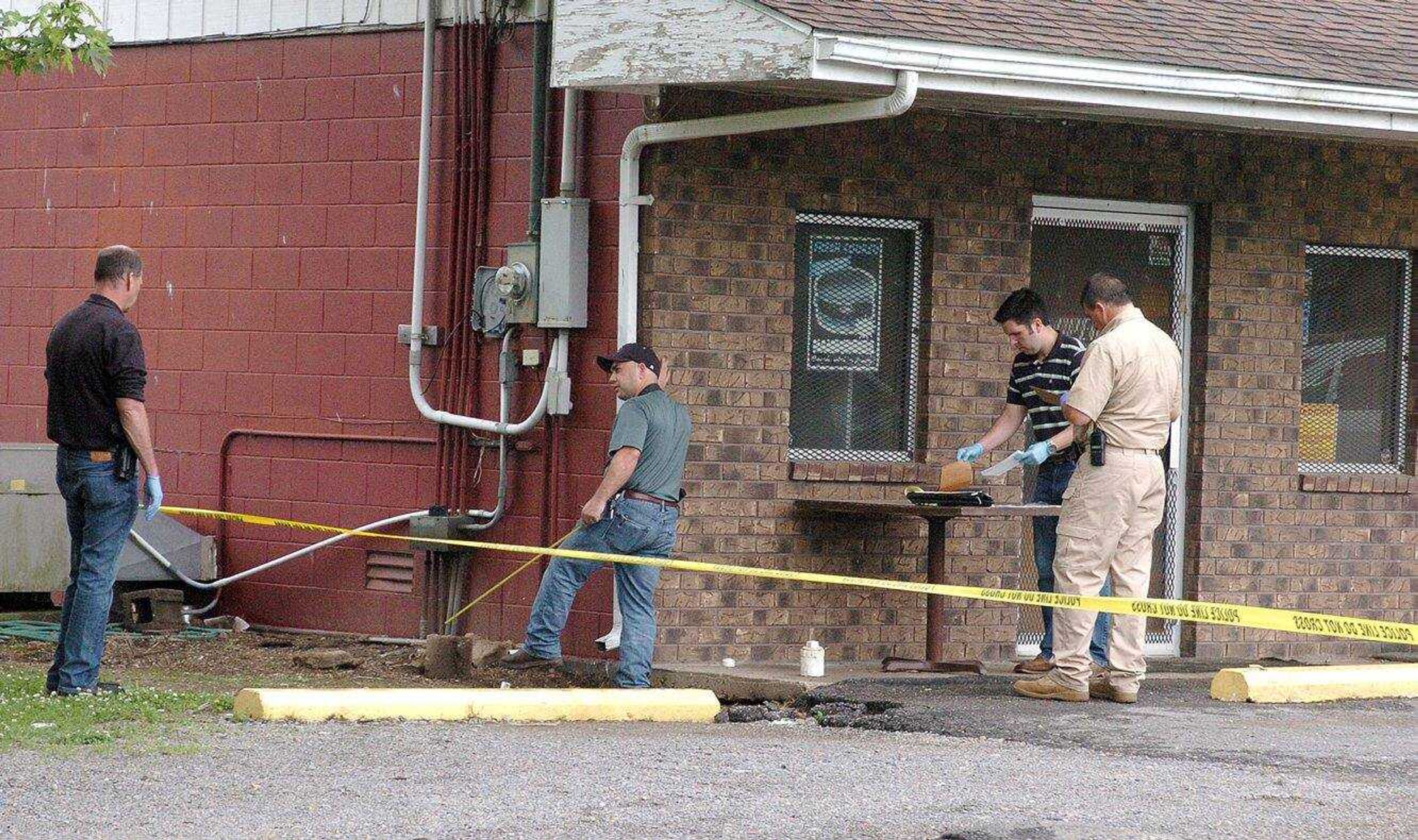 Law enforcement officers look for clues outside of D and L One Stop in Parma, Missouri, on Monday morning. One employee, Brenda Smith, was shot and killed during a  robbery. (Jill Bock ~ Standard Democrat)