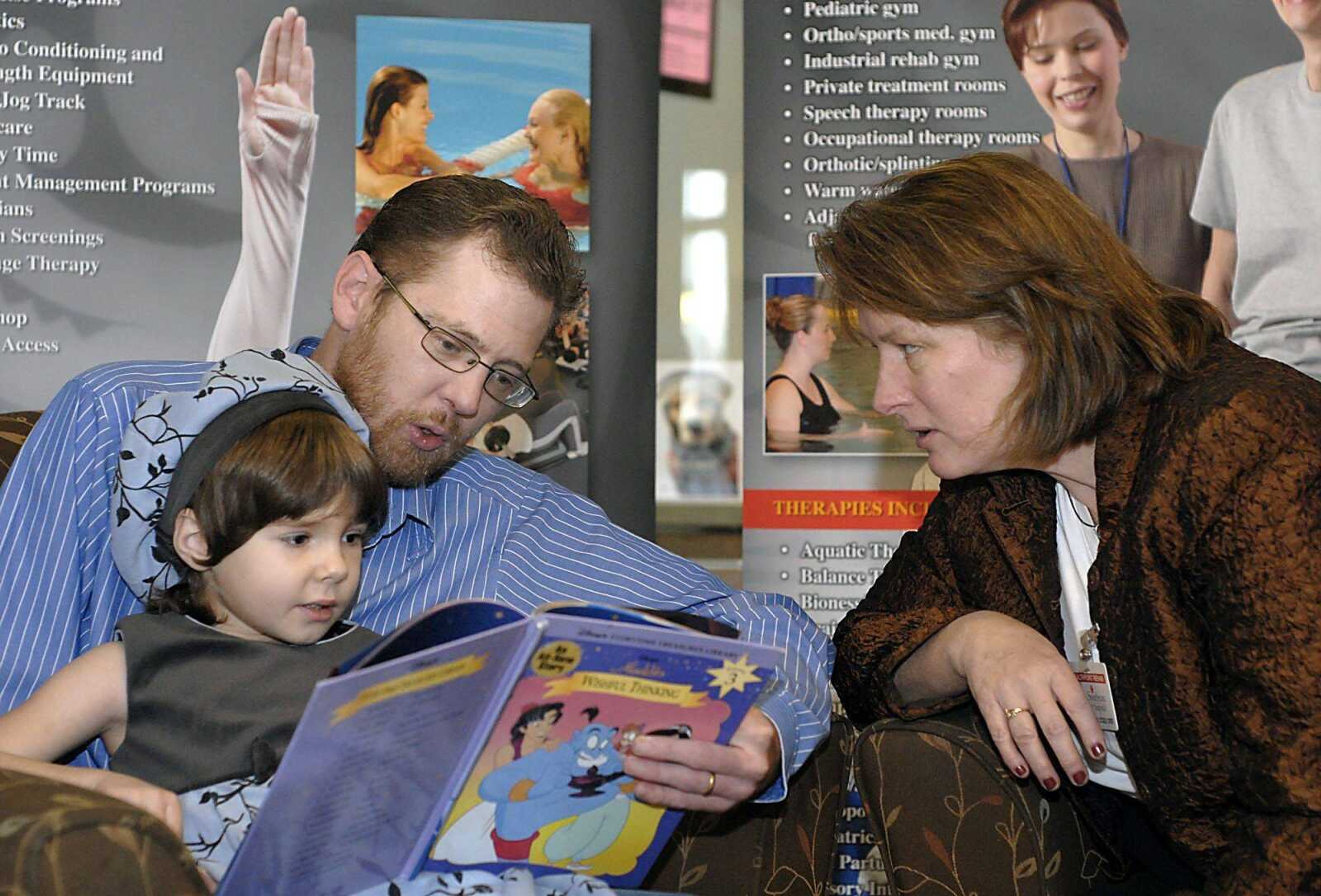 Scott Hartline works on reading to his daughter Gracie during a rehabilitation session with Catherine Tanksley on Nov. 19 at HealthPoint Rehab in Cape Girardeau. (Kit Doyle)