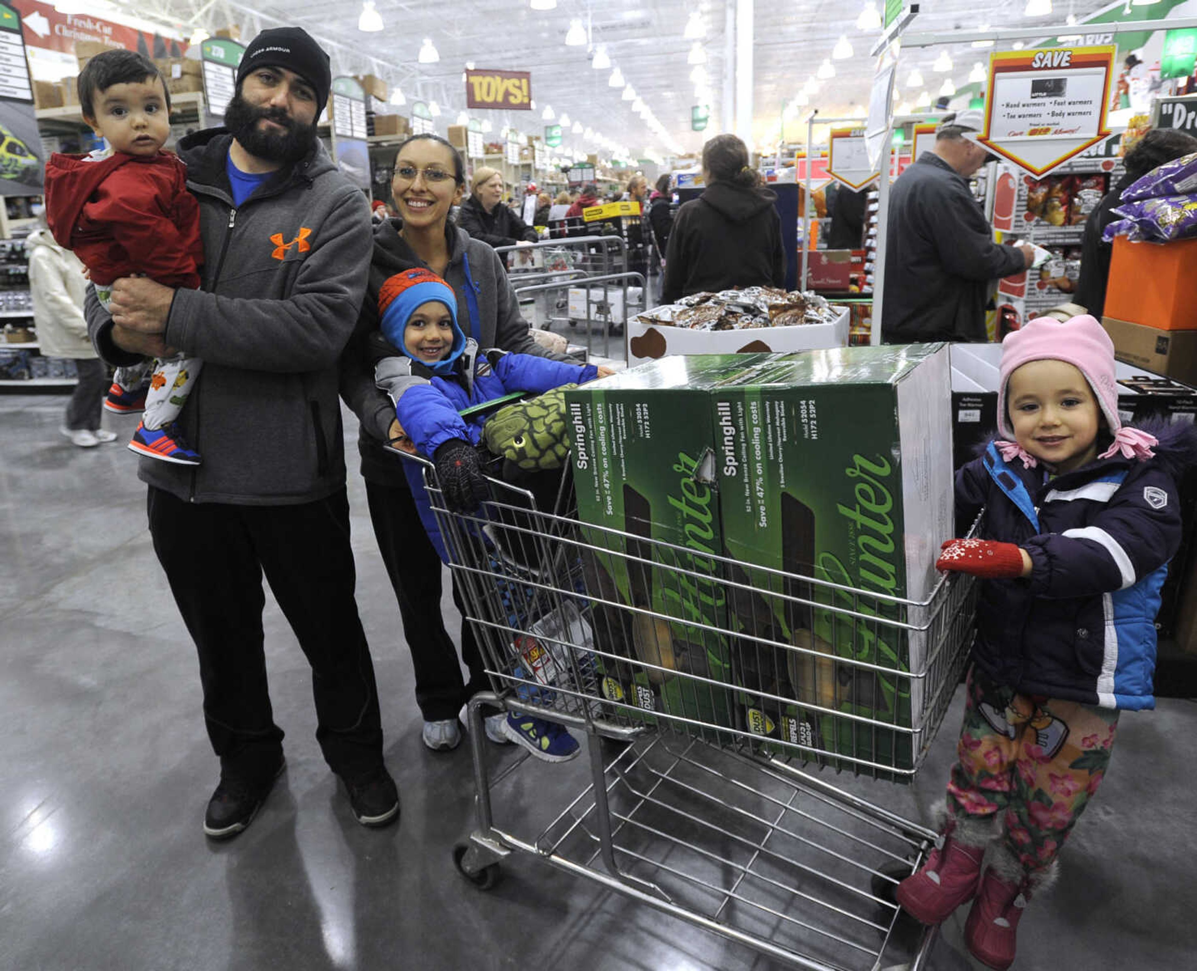 FRED LYNCH ~ flynch@semissourian.com
Phillip and Vanessa Ponce of Jackson pose with their children, Benjamin, left, Anthony and Rebekah, in the check-out line at Menards on Black Friday, Nov. 29, 2013 in Cape Girardeau.