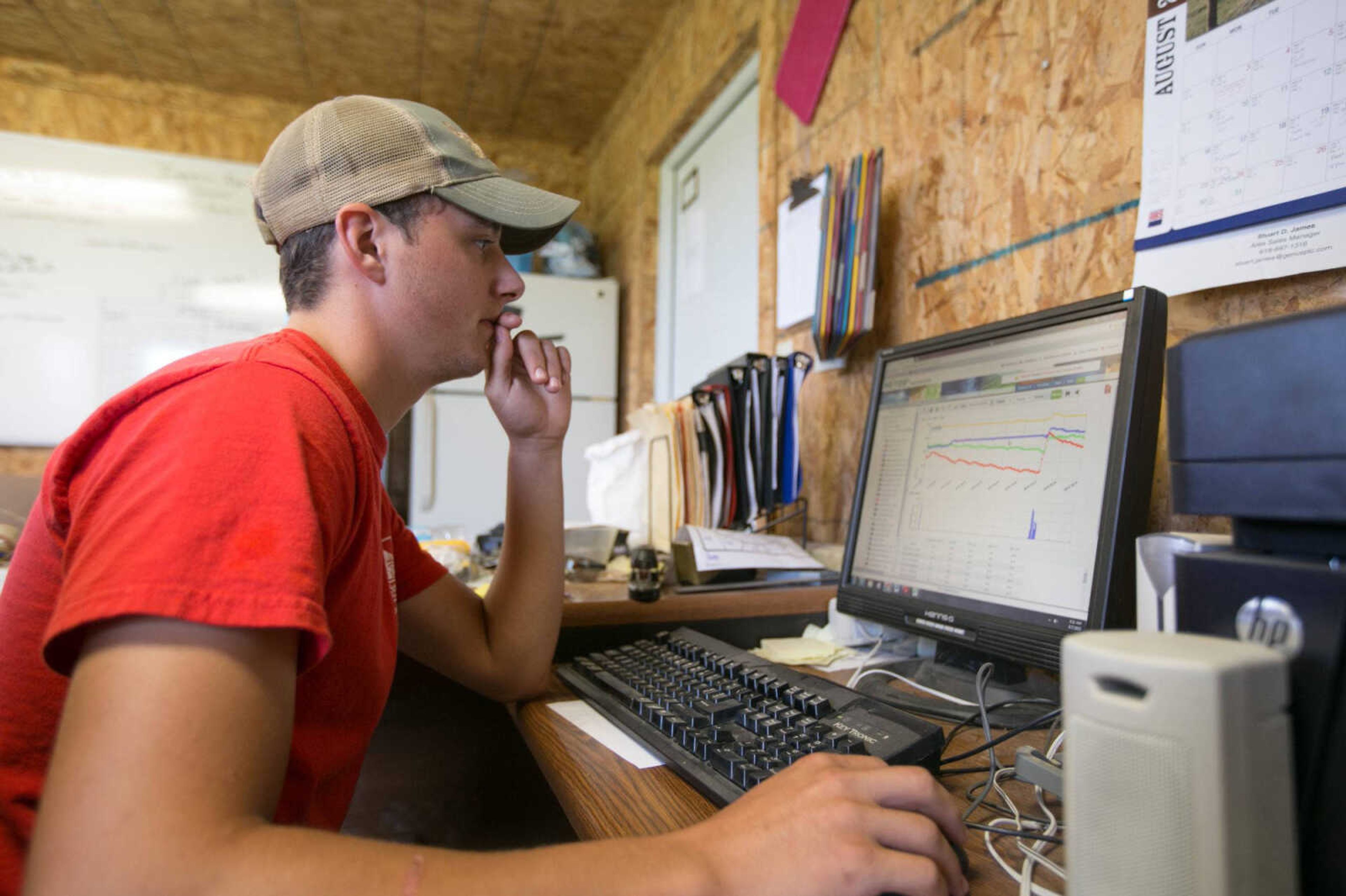 Collin Schabbing looks over the data from a soil sensor in the corn field Friday at the David M. Barton Agriculture Research Center near Gordonville. (Glenn Landberg)