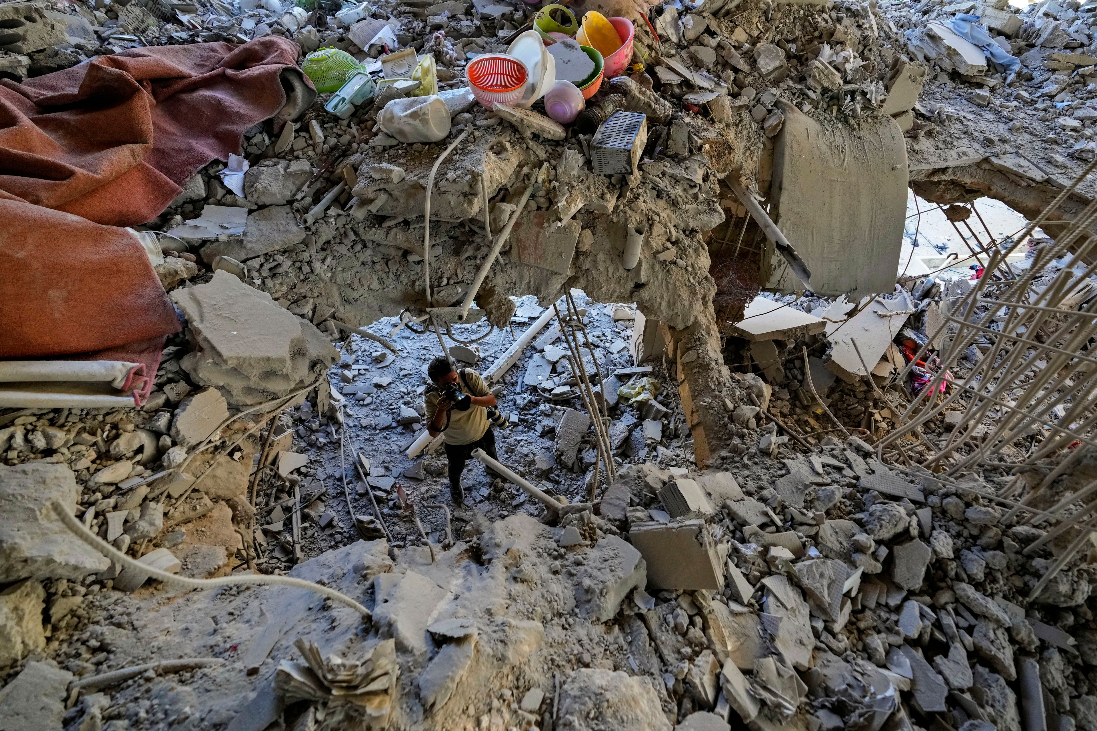 A photographer documents damage in a building that was hit by an Israeli airstrike in Beirut's southern suburb, Lebanon, Monday, Sept. 30, 2024. (AP Photo/Hassan Ammar)