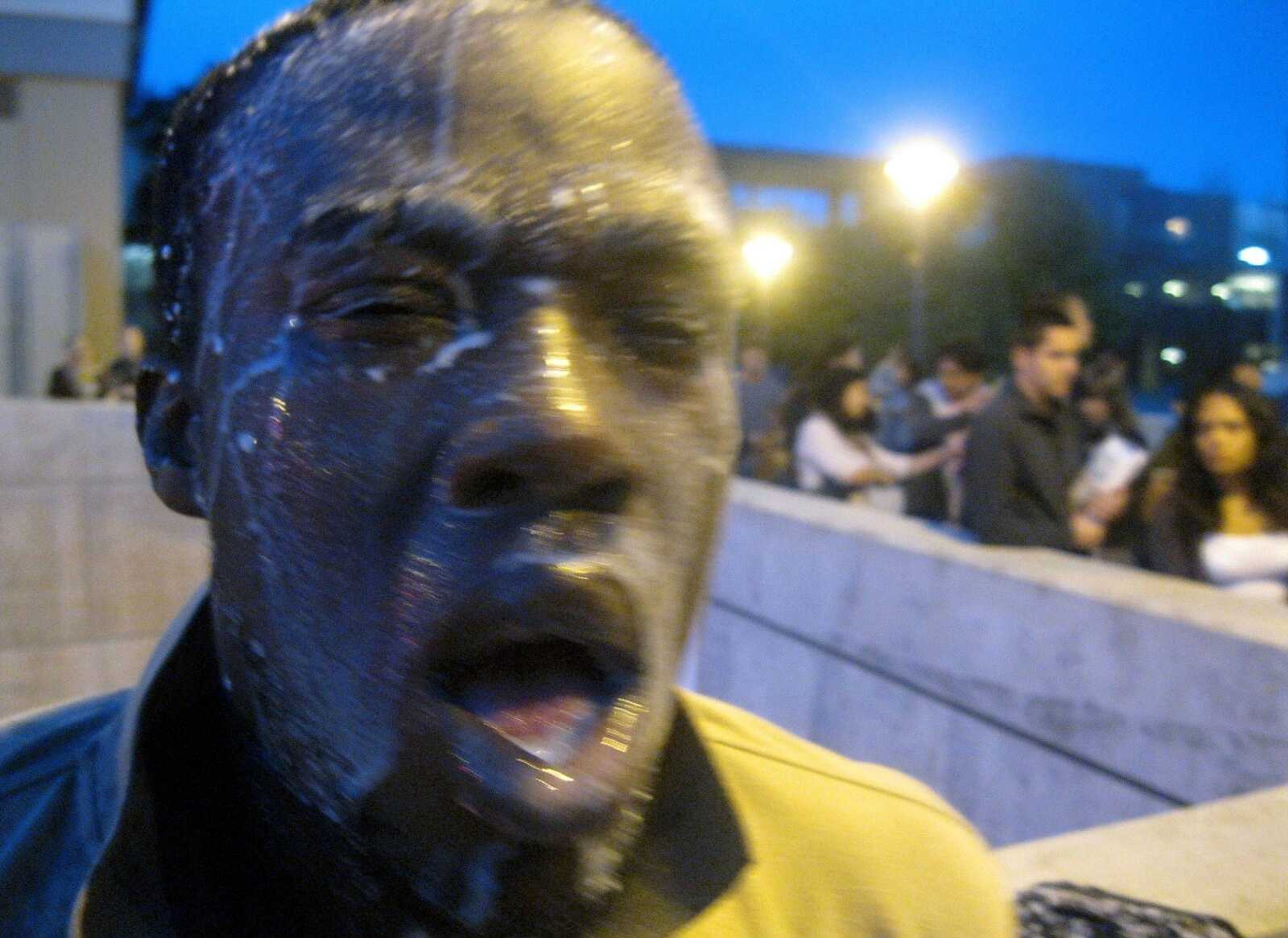 In this photo provided by David Steinman, Nnaemeka Alozie, campaign manager for Steinman, reacts with milk on his face after being sprayed with pepper spray during a protest on Tuesday, April 3, 2012, in Santa Monica, Calif. Campus police pepper-sprayed as many as 30 demonstrators after Santa Monica College students angry over a plan to offer high-priced courses tried to push their way into a trustees meeting Tuesday evening, authorities said. (AP Photo/Courtesy David Steinman)