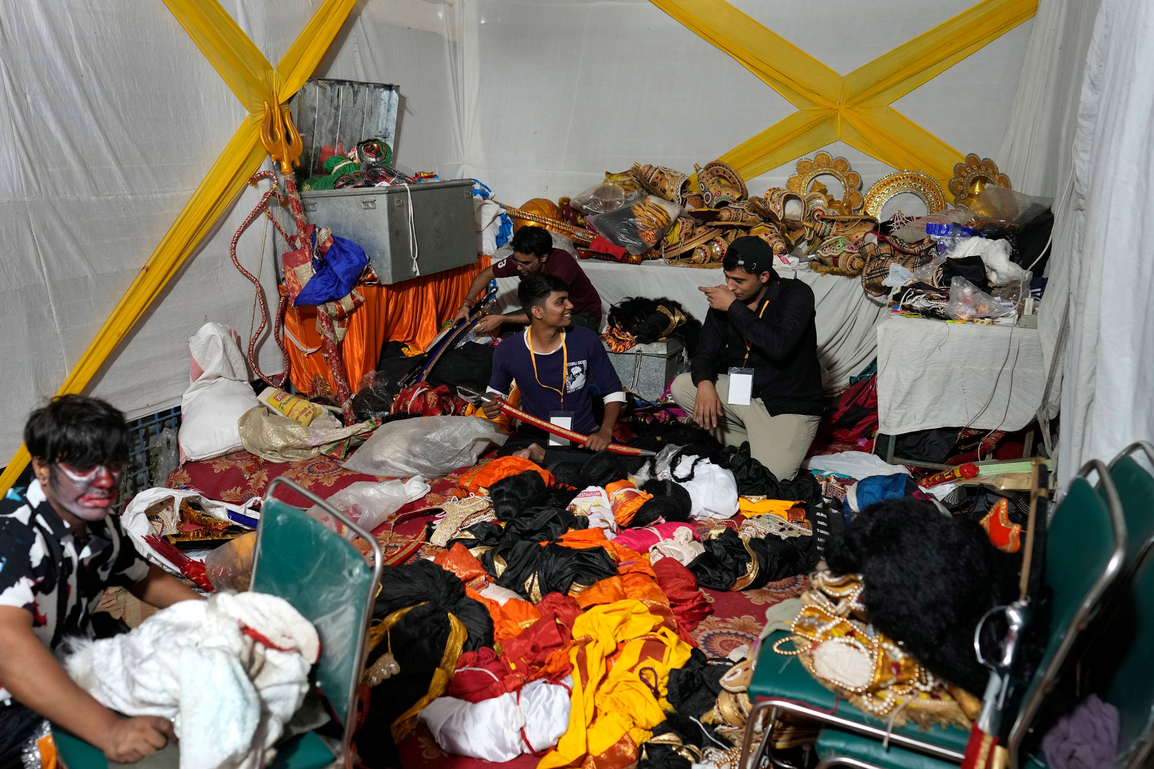 Production assistants sort costumes backstage during Ramleela, a dramatic folk re-enactment of the life of Hindu god Rama according to the ancient Hindu epic Ramayana, in New Delhi, India, Wednesday, Oct. 9, 2024. (AP Photo/Manish Swarup)