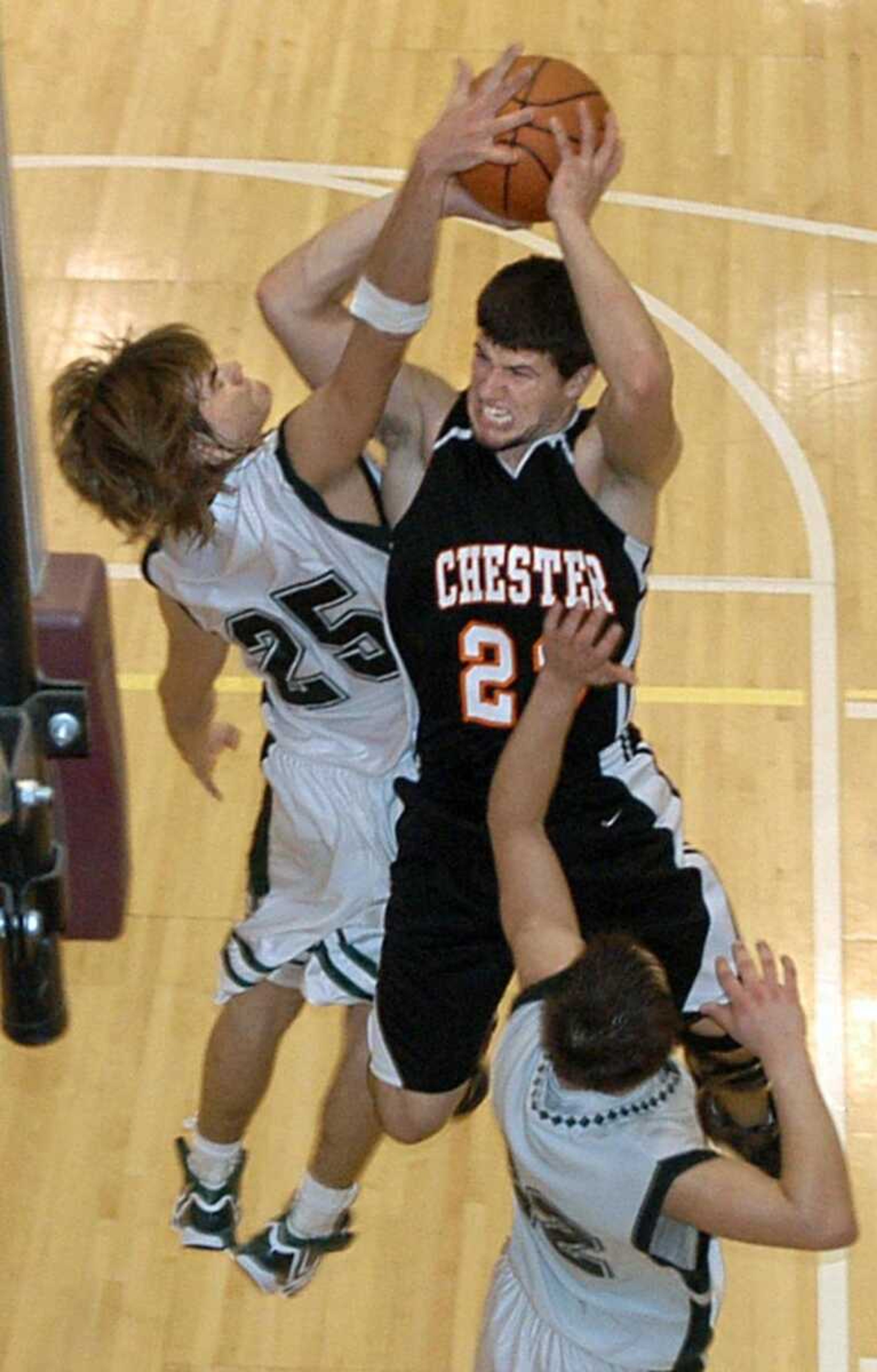 Chester's Dylan Clark drove to the basket but had his shot blocked by Perryville's Brent Roth while Mike Fritsche also defended in the fourth period of Saturday's game at the Heartland Hoopfest at the Perry Park Center. The Pirates held on for a 45-41 victory.