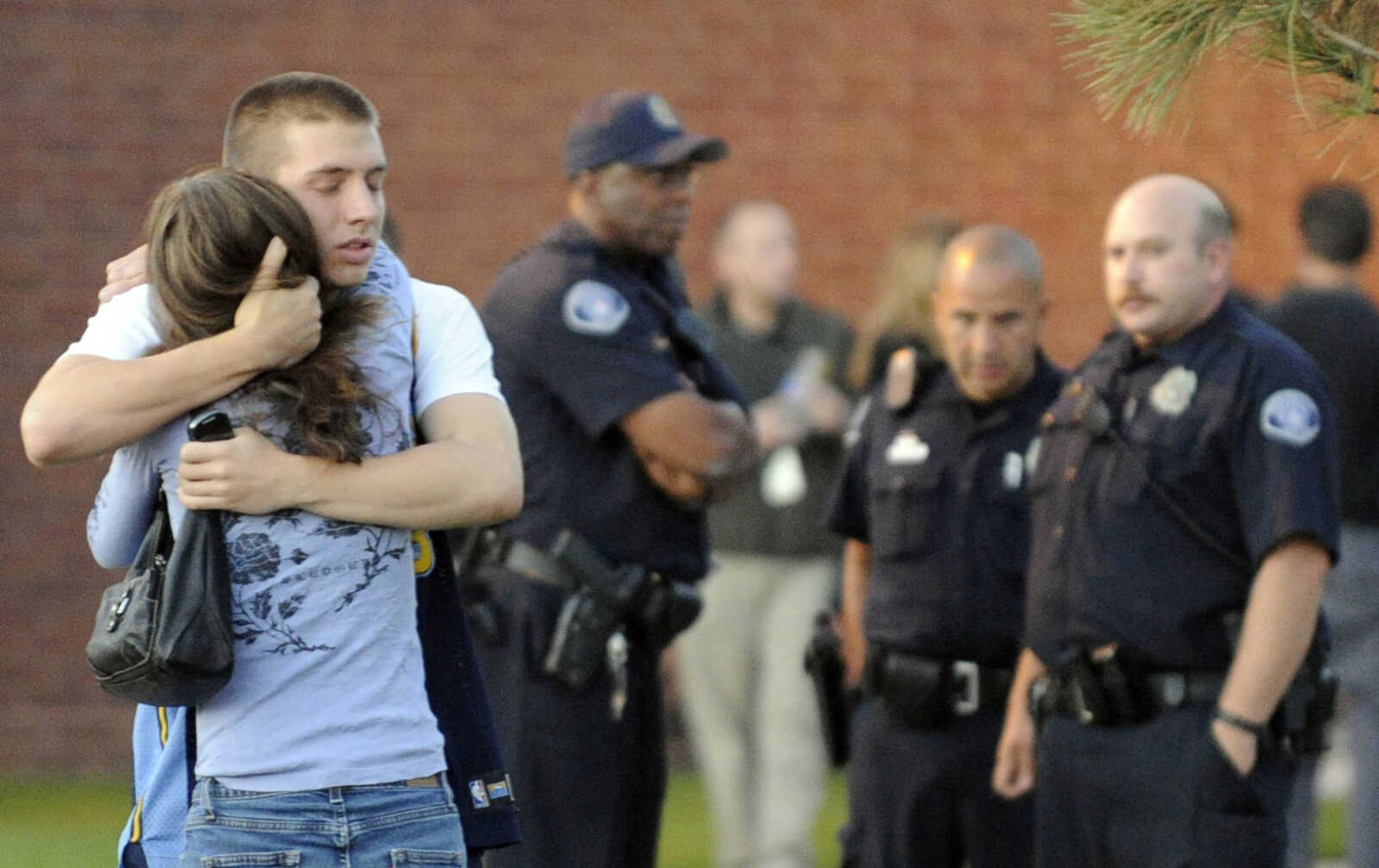 Eyewitness Jacob Stevens, 18, hugs his mother Tammi Stevens after being interview by police outside Gateway High School where witnesses were brought for questioning Friday, July 20, 2012 in Aurora, Colo.  A gunman wearing a gas mask set off an unknown gas and fired into the crowded movie theater killing 12 people and injuring at least 50 others, authorities said.  (AP Photo/The Denver Post,  RJ Sangosti) TV, INTERNET AND MAGAZINES CALL FOR RATES AND TERMS