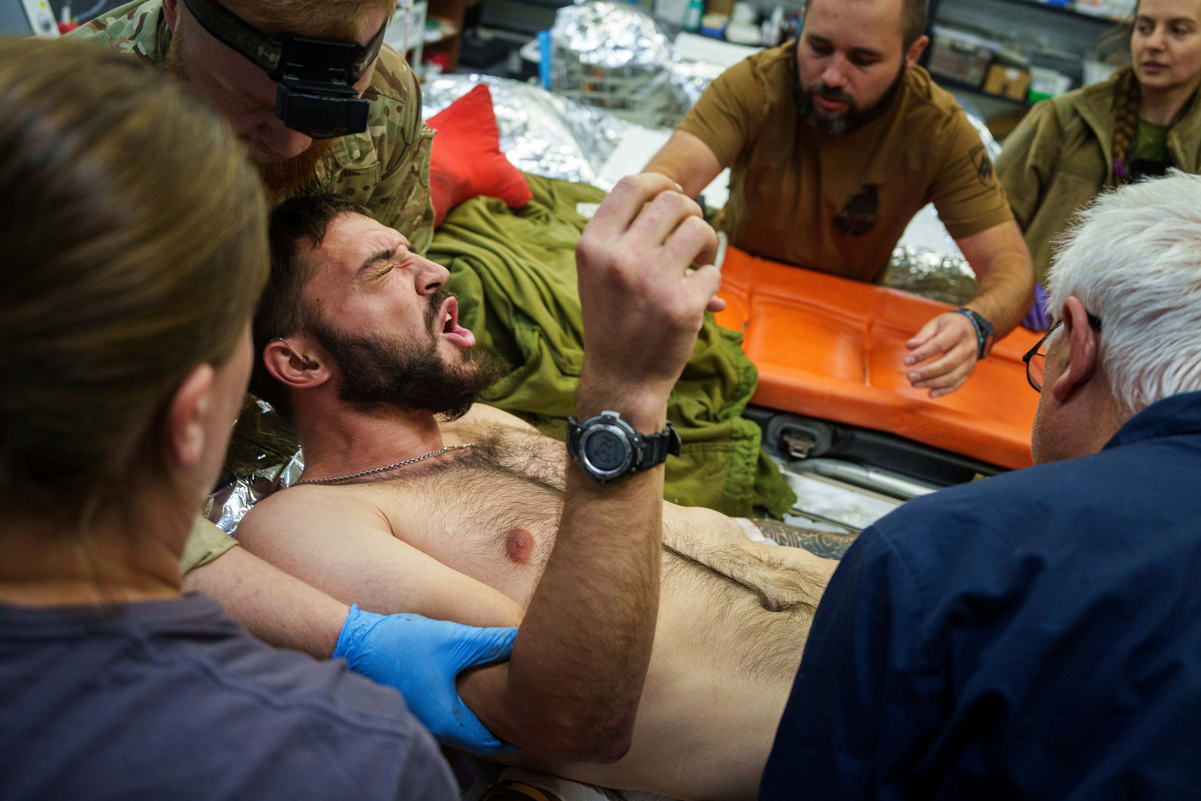 Ukrainian military medics of the Azov brigade move an injured comrade on a stretcher, at the stabilization point near Toretsk, Donetsk region, Ukraine, Tuesday, Sept. 24, 2024. (AP Photo/Evgeniy Maloletka)