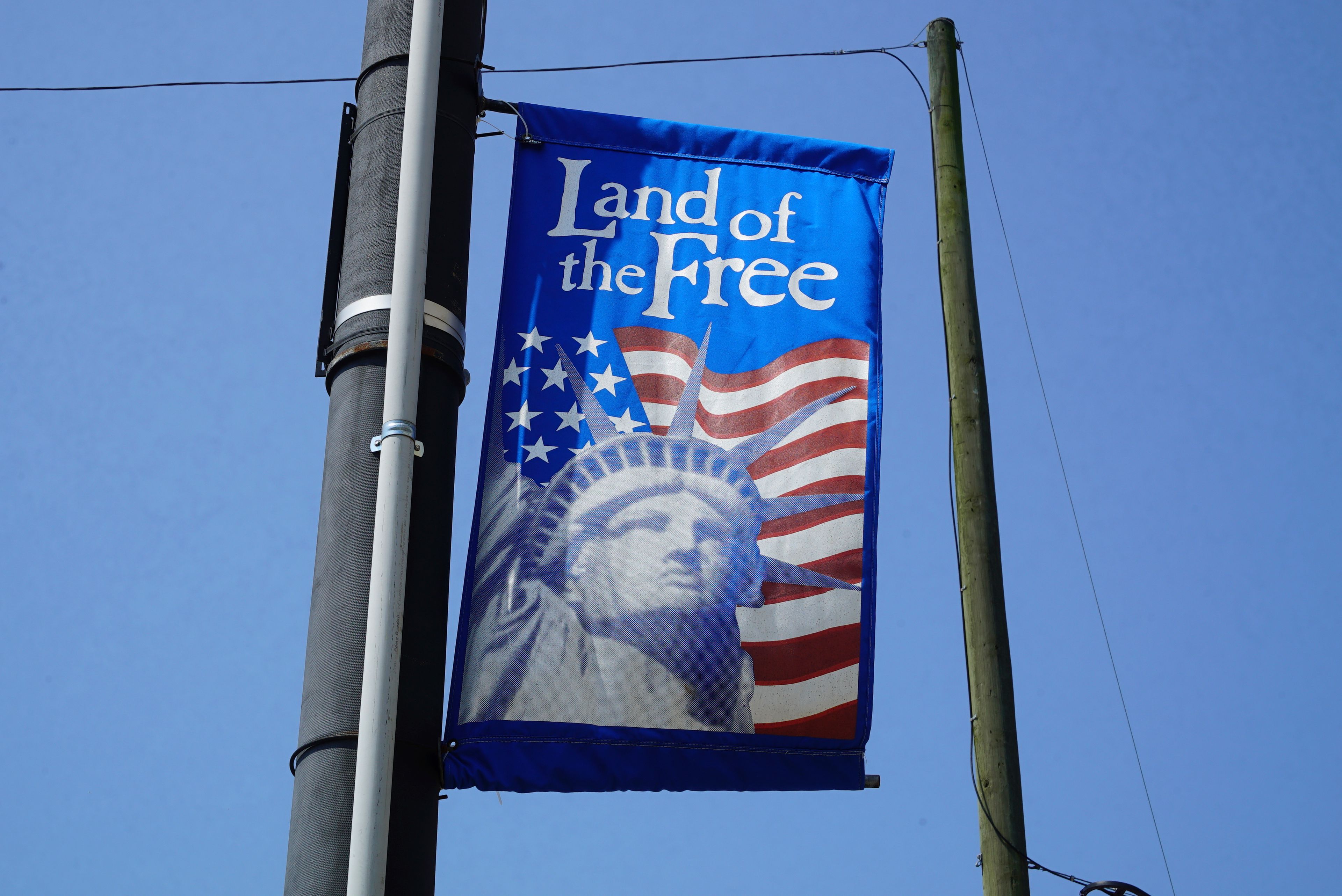 A patriotic banner hangs from a utility pole in downtown Mount Olive, N.C., on Monday, July 15, 2024. (AP Photo/Allen G. Breed)