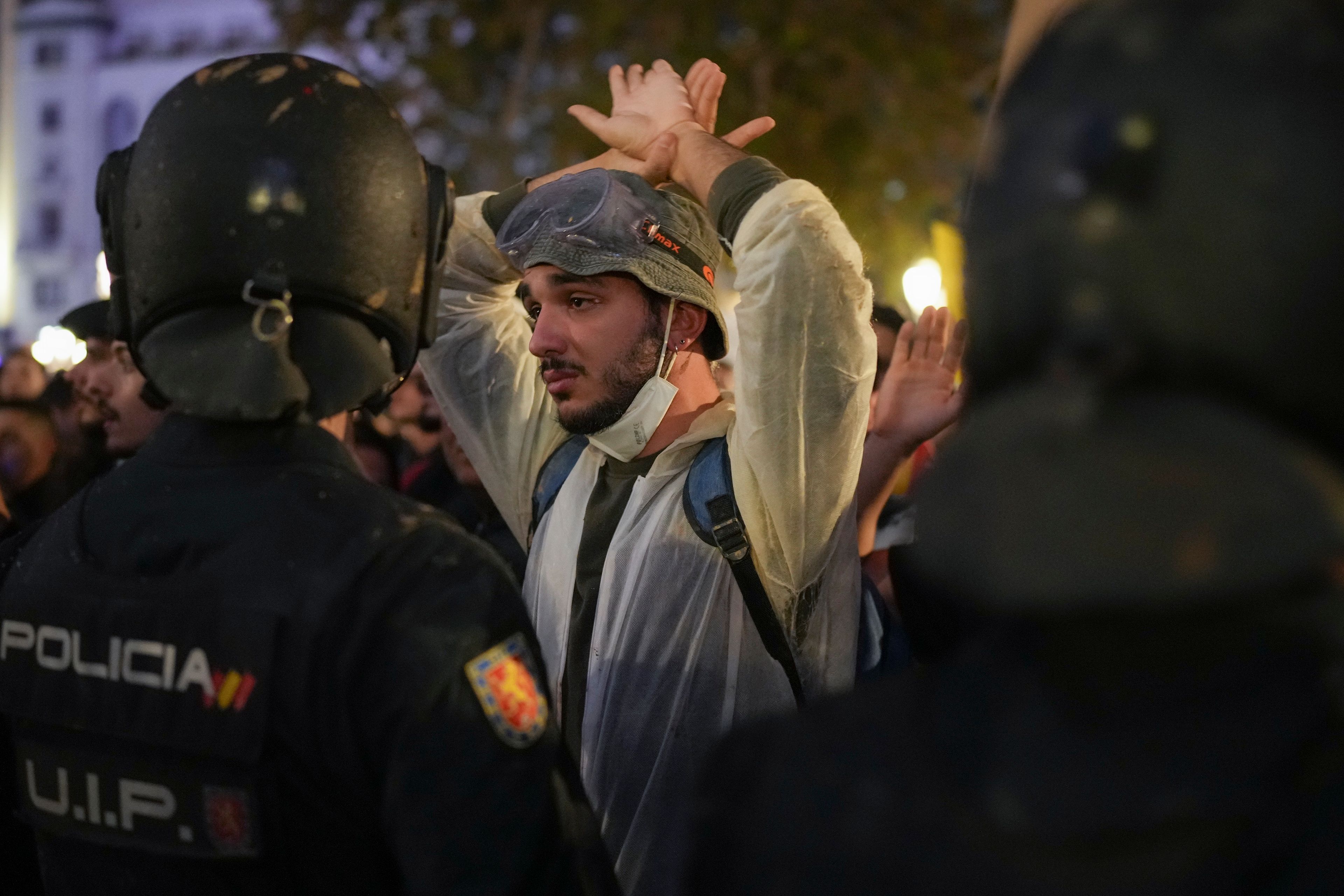 A demonstrator holds his hands up in front of riot police during a protest organized by social and civic groups, denouncing the handling of recent flooding under the slogan "Mazón, Resign," aimed at the president of the regional government Carlos Mazon, in Valencia, Spain, Saturday, Nov. 9, 2024. (AP Photo/Emilio Morenatti)