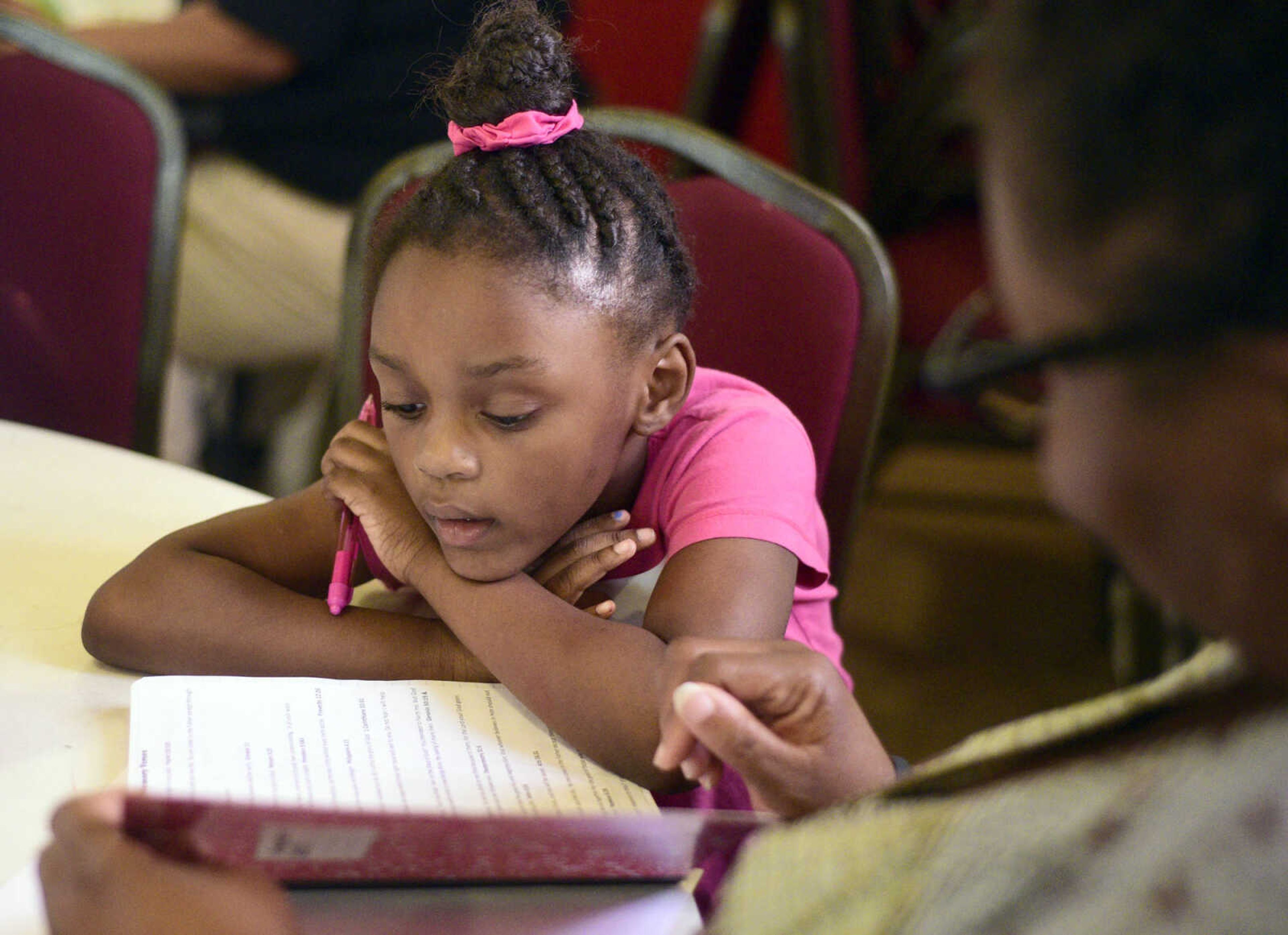 Lauren Washington reads aloud with help from Natalie Giles on Monday, Aug. 14, 2017, during the Salvation Army's after school program at The Bridge Outreach Center in Cape Girardeau.