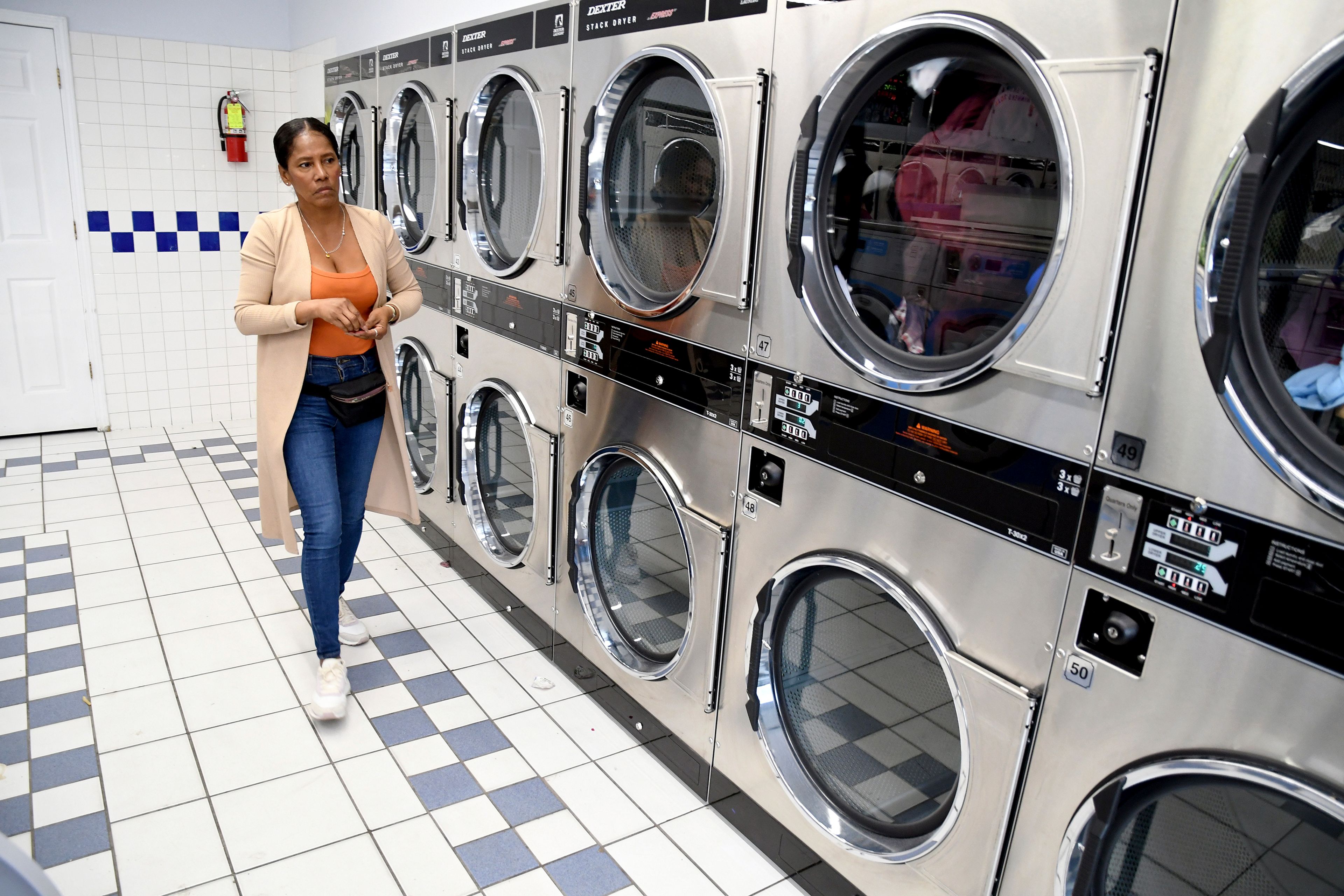 Sofia Roca, an immigrant from Colombia, washes clothes at a laundromat in Aurora, Colorado, on March 29, 2024. (AP Photo/Thomas Peipert)