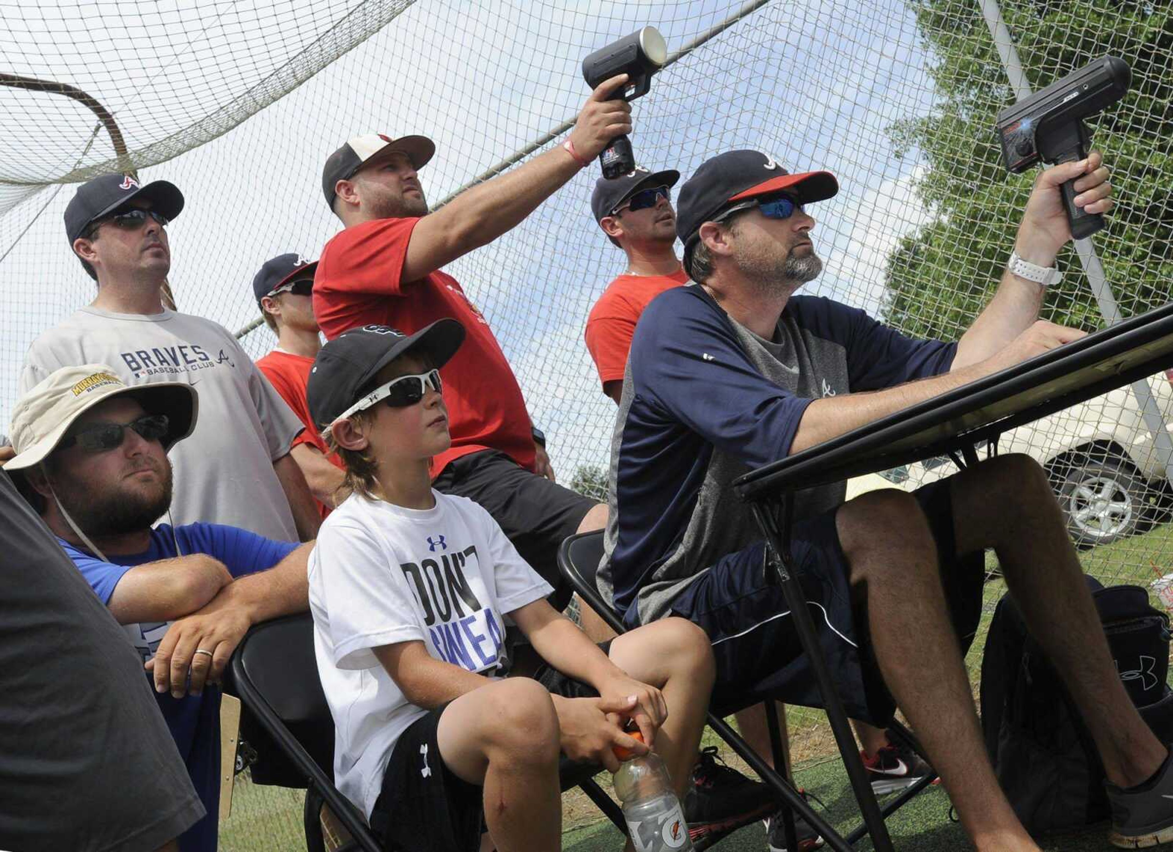 Jon David French, right, records the speed of pitches as Terry Tripp, standing left, watches with others Wednesday at the Atlanta Braves tryout camp in Kennett, Missouri. French, a Braves scout, and Tripp, an area supervisor with the organization, have been instrumental in the Braves finding baseball talent in the area. The team has selected six players from Southeast Missouri over the last three drafts. (Fred Lynch)