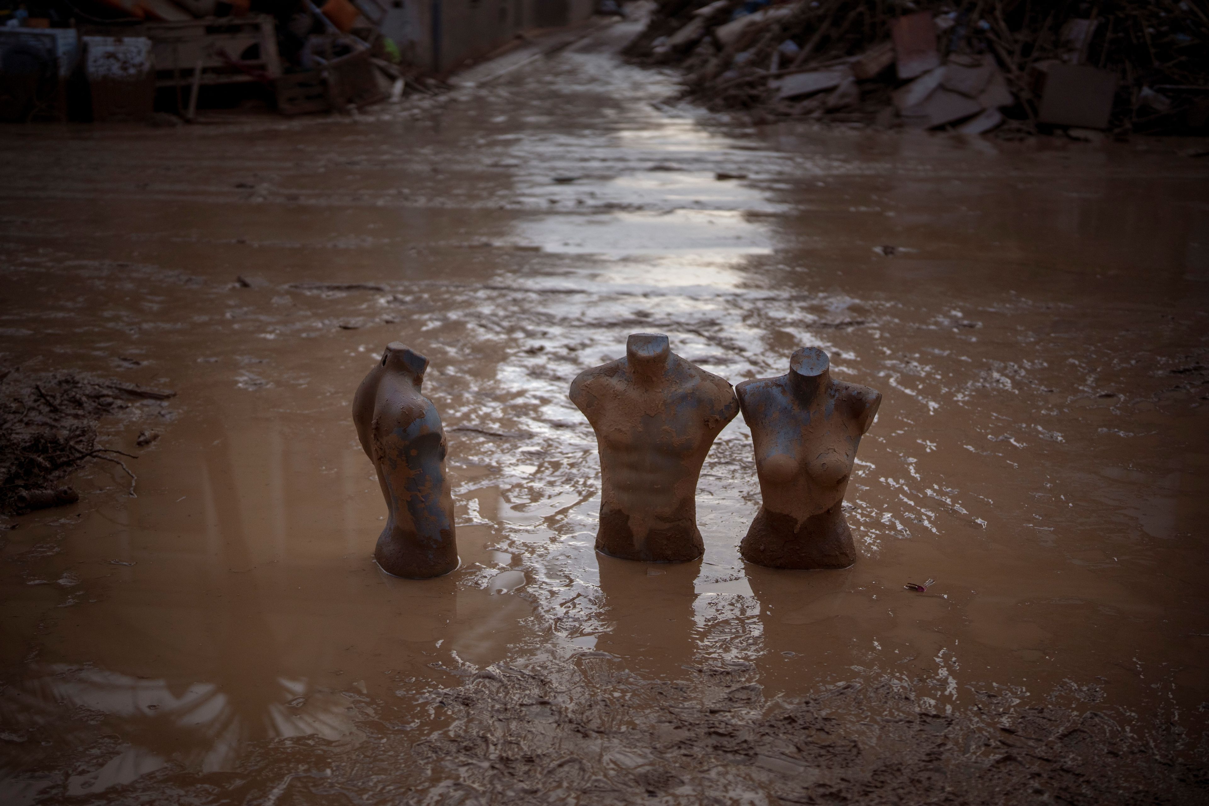 Mannequins are photographed partially buried in mud in an area affected by floods in Masanasa, Valencia, Spain, Wednesday, Nov. 6, 2024. (AP Photo/Emilio Morenatti)