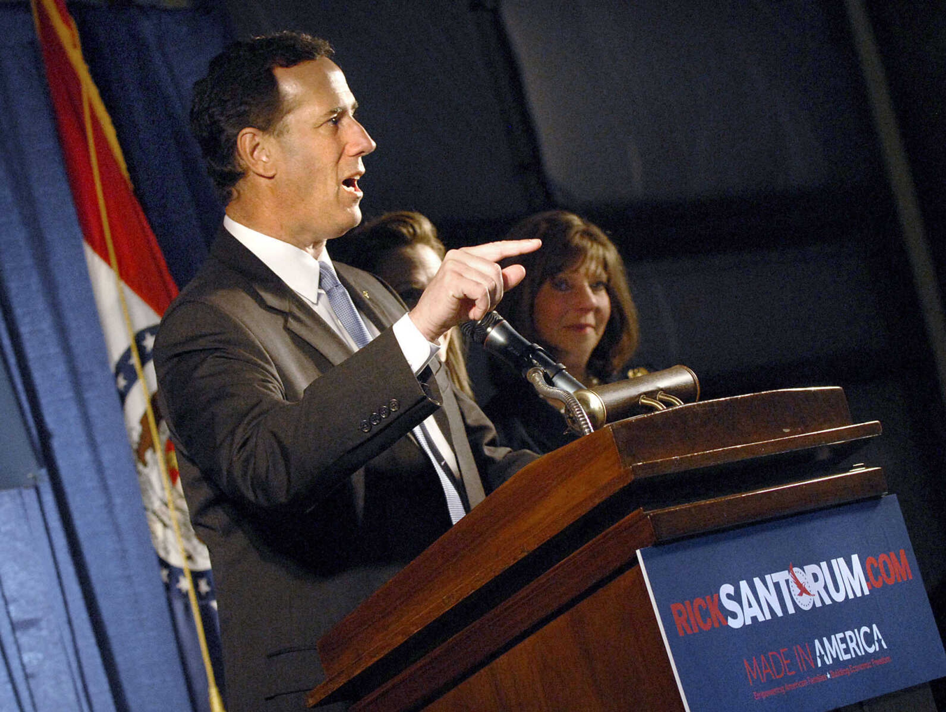 LAURA SIMON ~ lsimon@semissourian.com
Rep. Jo Ann Emerson listens as Republican presidential candidate Rick Santorum gives a brief statement before heading into the crowd in the hanger at the Cape Girardeau Regional Airport for photos and autographs Saturday night, March 10, 2012 during his campaign stop. Santorum was heading to Tupelo, Miss. following his stop in Cape Girardeau,Mo.