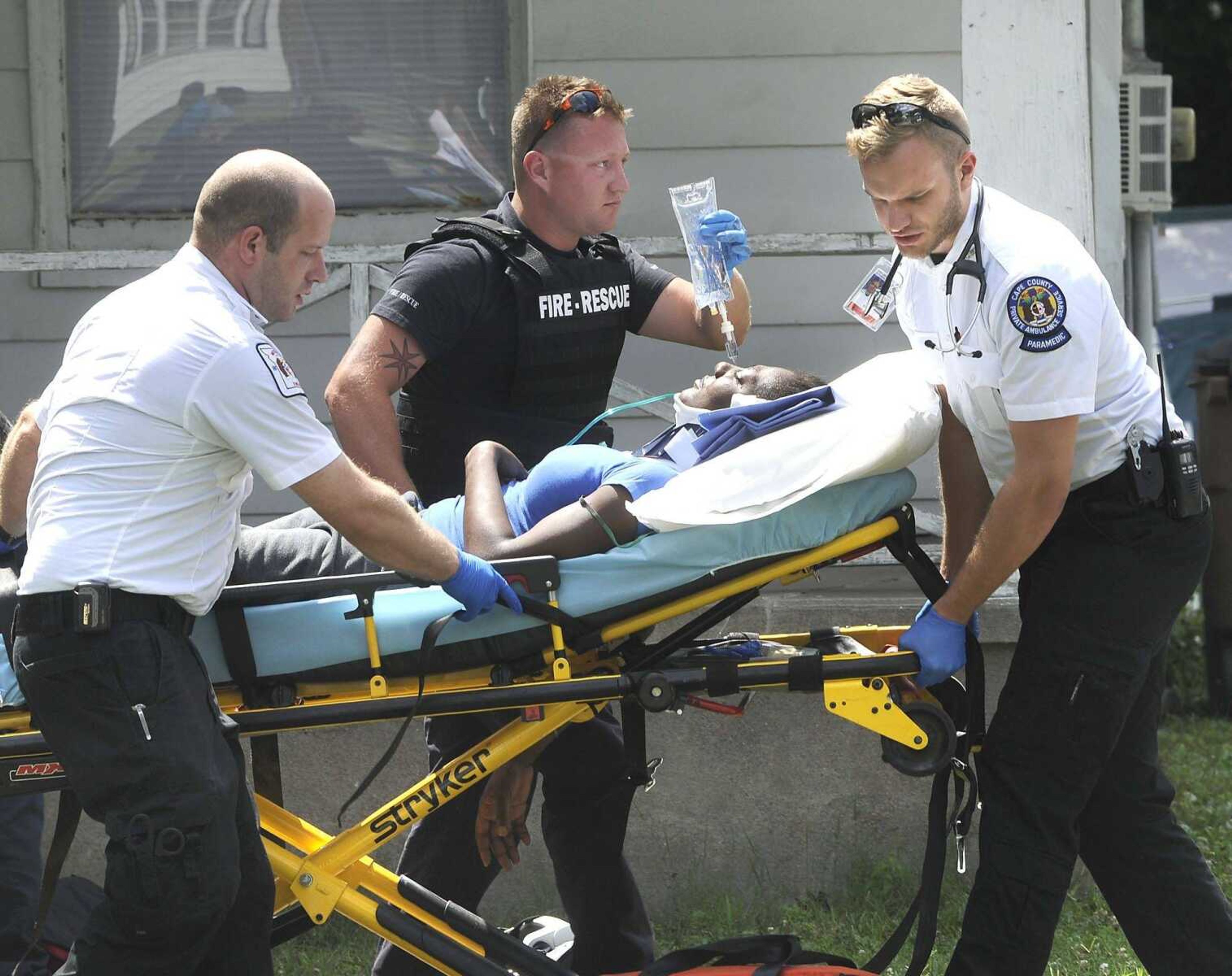 Paramedics transport a shooting victim to an ambulance June 29 outside a house at 401 S. Hanover St. in Cape Girardeau. (Fred Lynch)