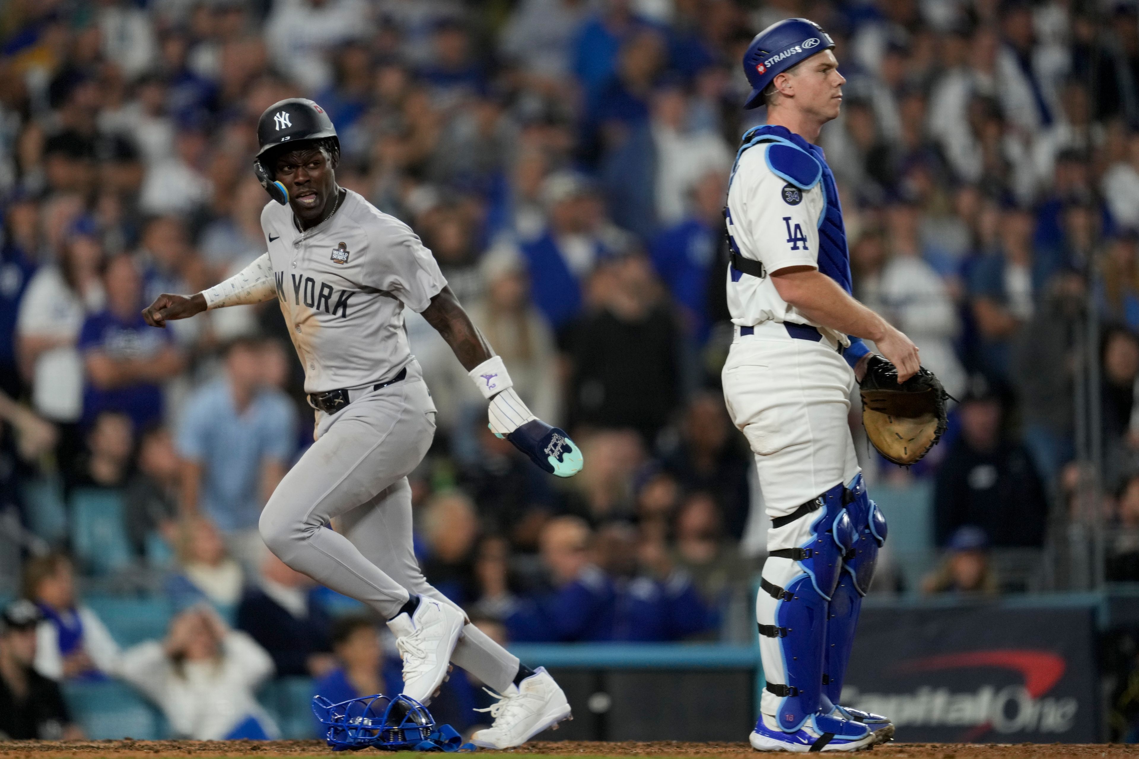 New York Yankees' Jazz Chisholm Jr. scores past Los Angeles Dodgers catcher Will Smith on a fielders choice by Anthony Volpe during the 10th inning in Game 1 of the baseball World Series, Friday, Oct. 25, 2024, in Los Angeles. (AP Photo/Ashley Landis)