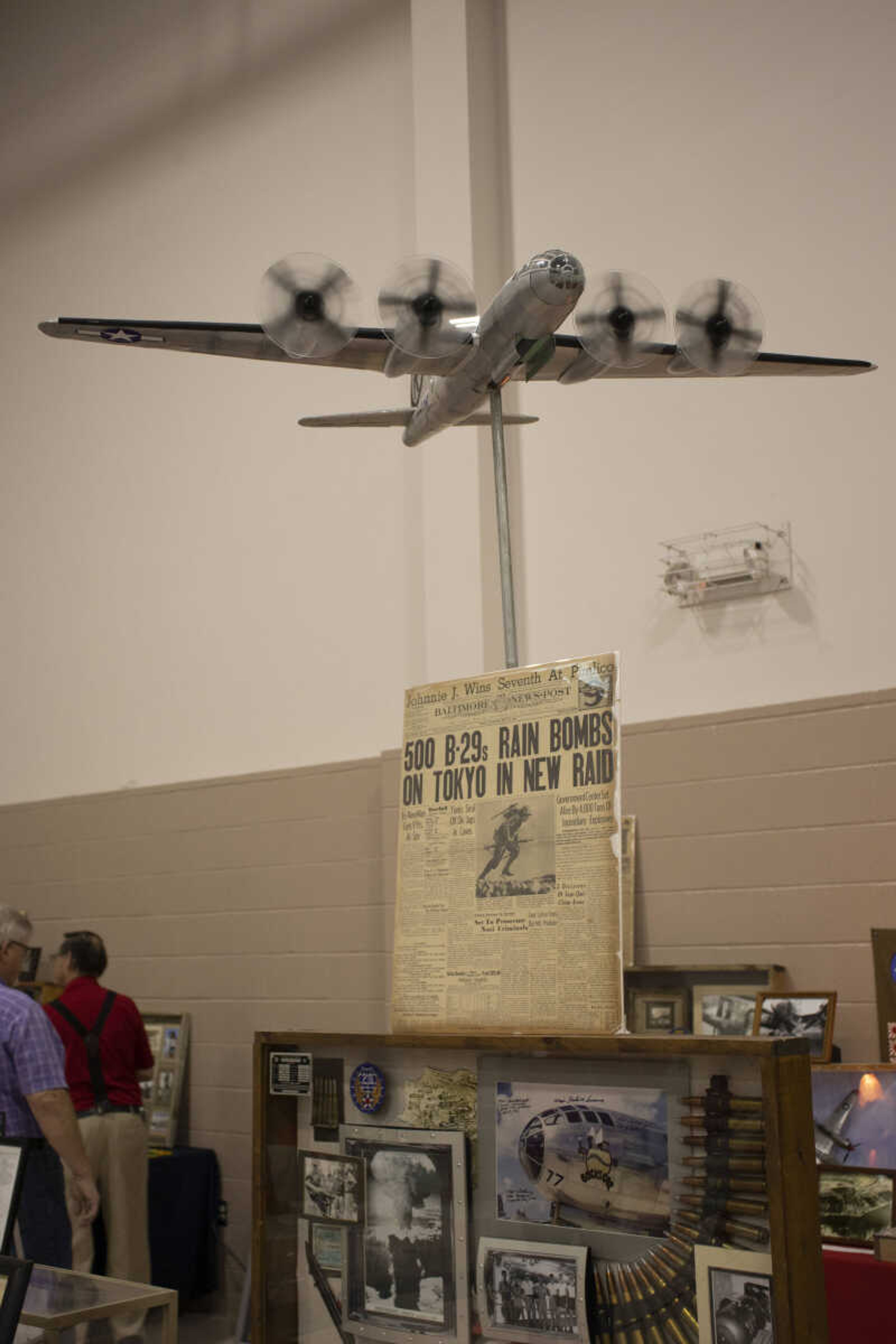 A model aircraft stands over a table full of historical items at the dinner.