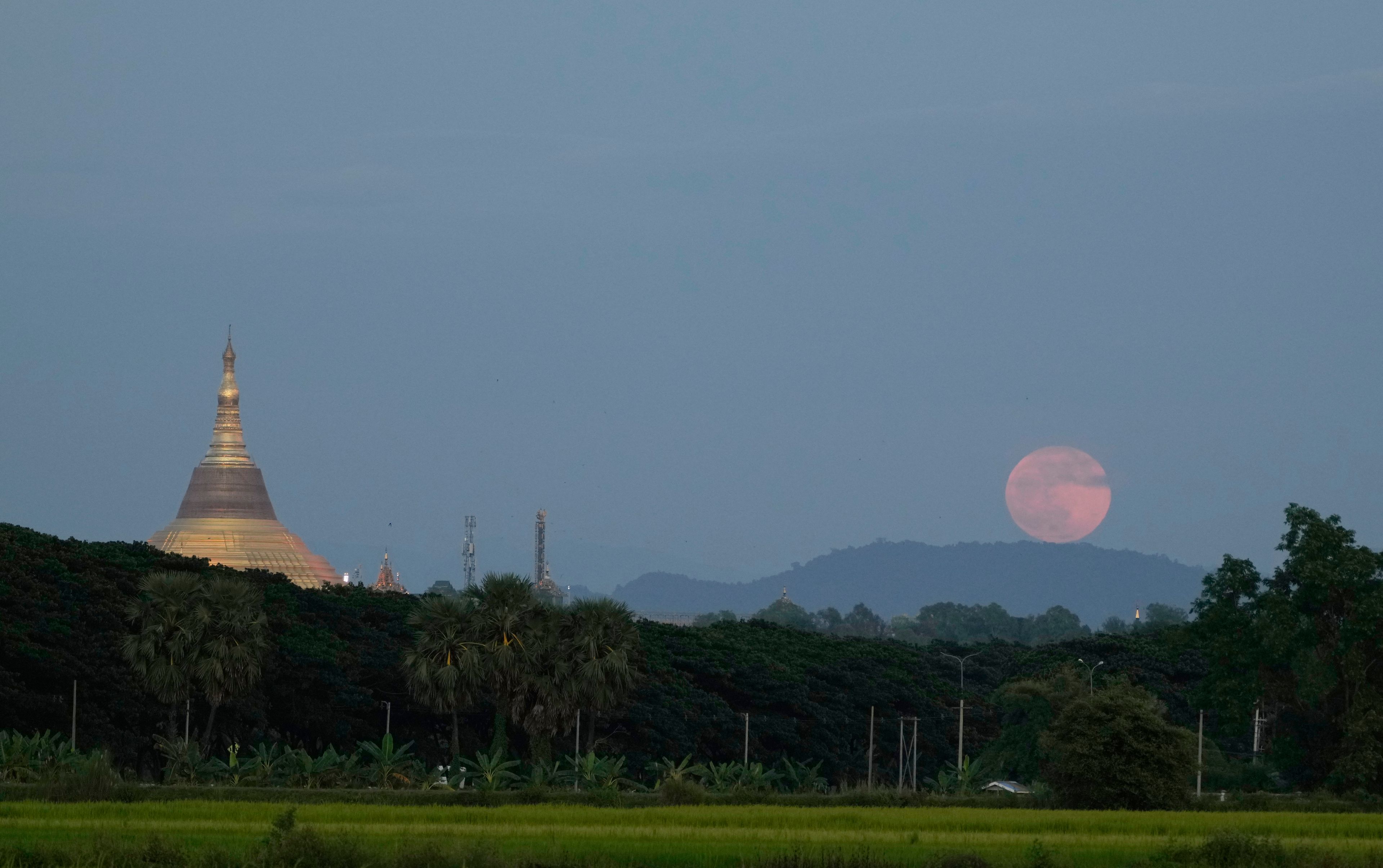 The moon rises beside the Uppatasanti Pagoda seen from Naypyitaw, Myanmar, Thursday, Oct. 17, 2024. (AP Photo/Aung Shine Oo)