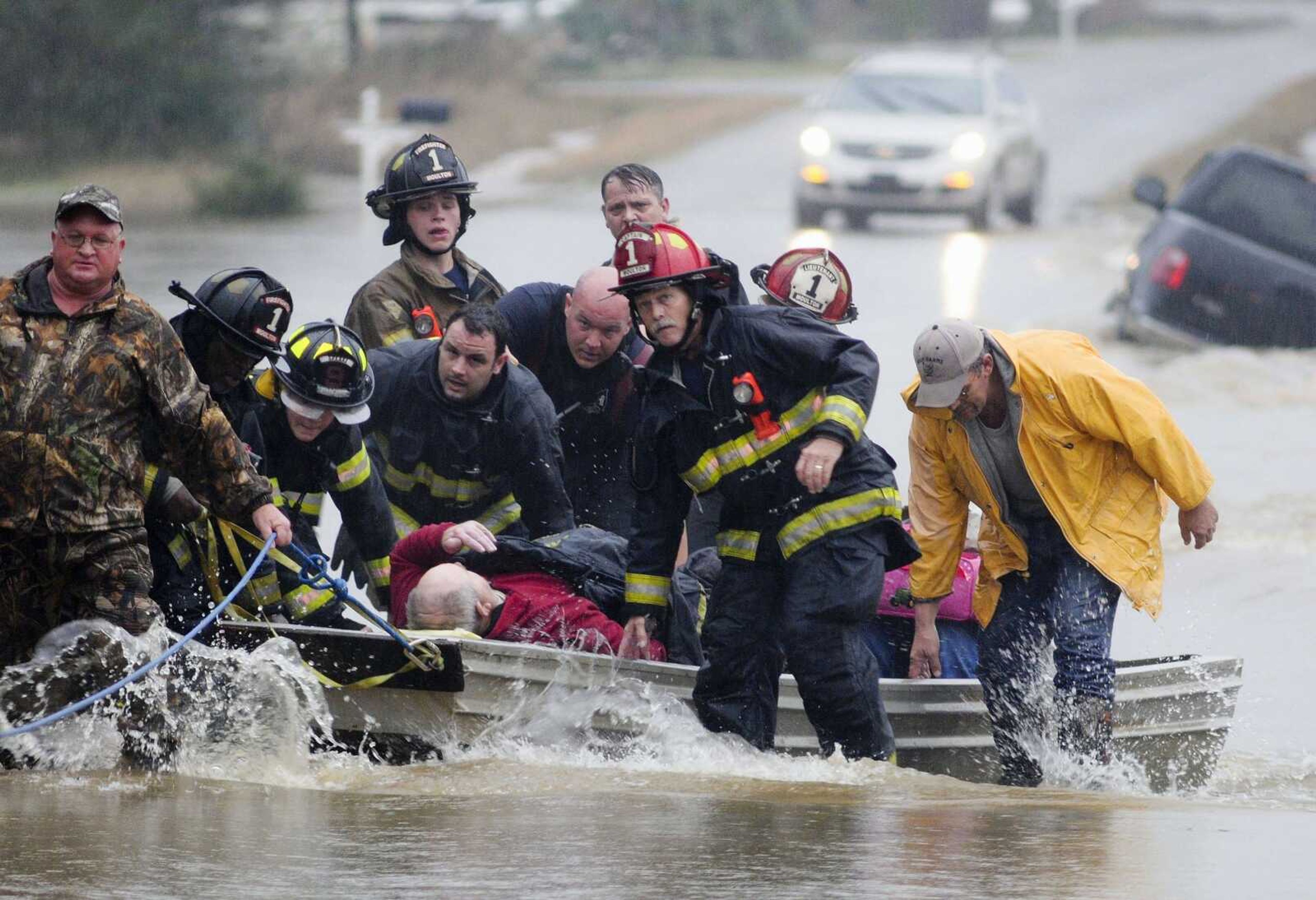 Emergency officials transport James Simmons by boat because water over Byler Road prevented them from reaching him Friday in Moulton, Alabama. They carried him by boat before loading him into an ambulance. Unseasonably warm weather helped spawn severe storms Friday and Saturday after violent storms in the Southeast left dozens of families homeless by Christmas Eve. (Deangelo McDaniel ~ The Decatur Daily via AP)