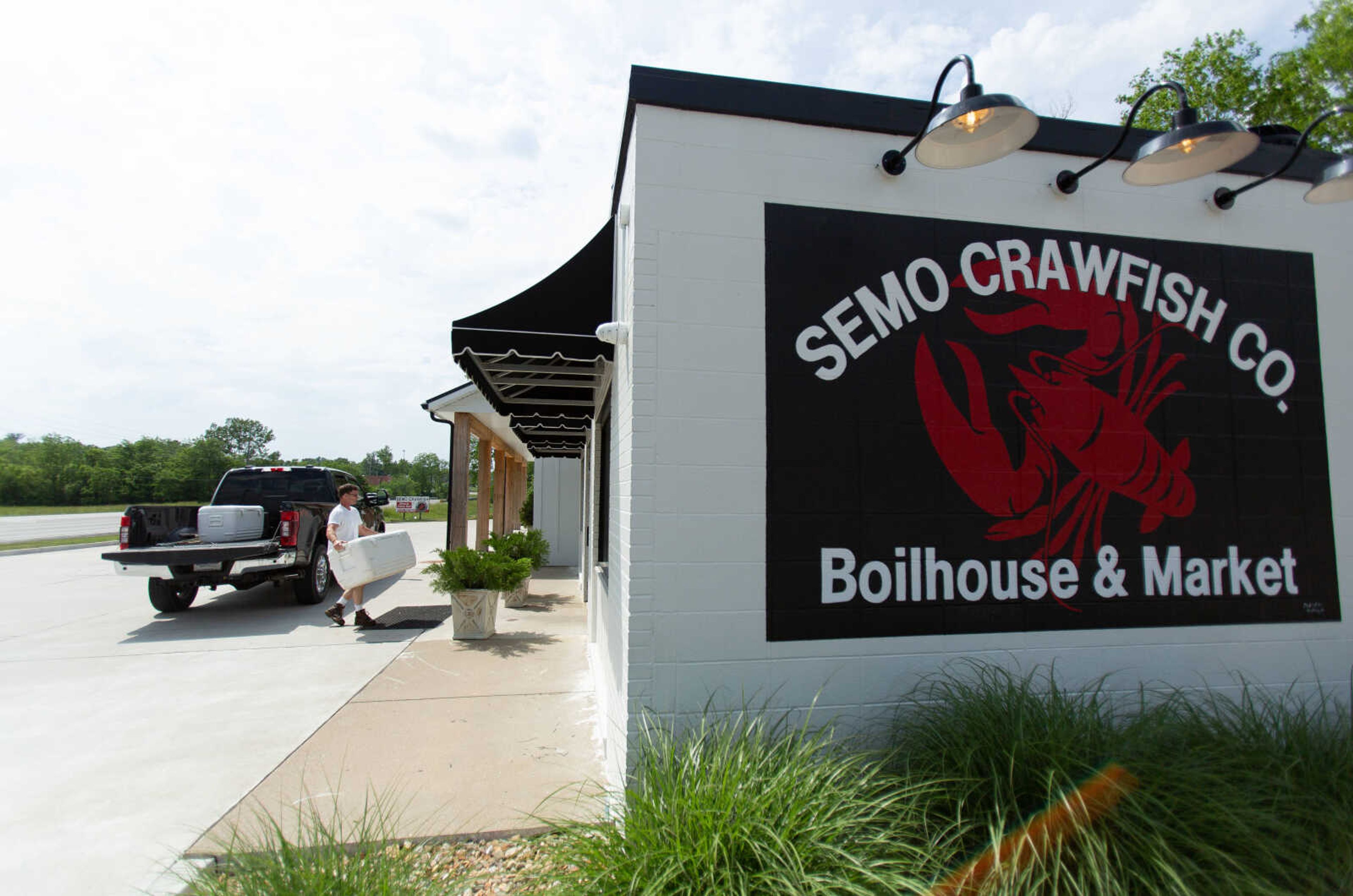 Ben Hunter and his son Benjamin Hunter carry in a cooler of freshly-caught crawfish at their restaurant, Semo Crawfish Company, in Jackson. The family cleans the crawfish on one side of the building and serves the crawfish to diners on the other.