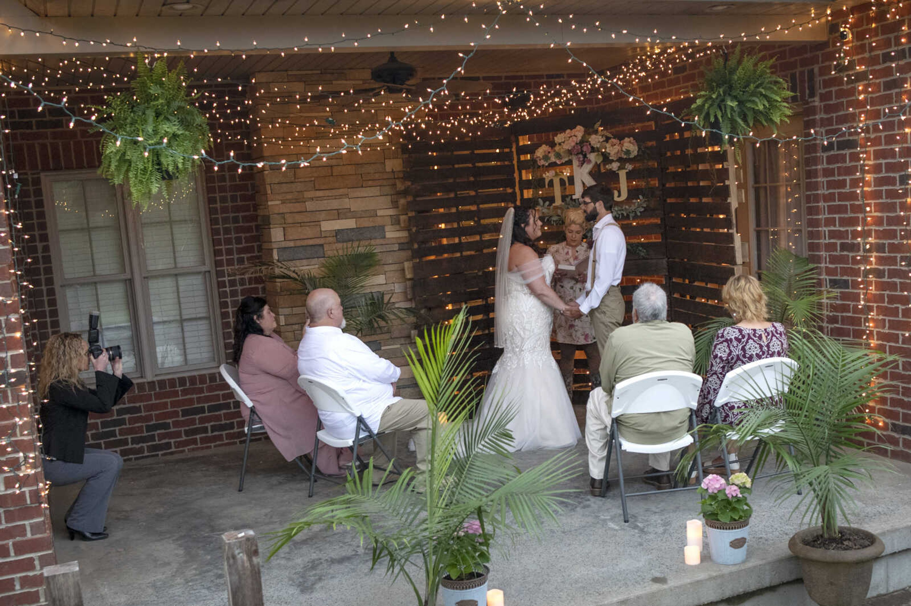 Jenni Heisserer, originally of Scott City, Missouri, and now Cape Girardeau, and Trevor Kroenung of Cape Girardeau hold hands during their wedding ceremony officiated by Brittany Felter of Scott City on Saturday, April 25, 2020, in Scott County, Missouri.