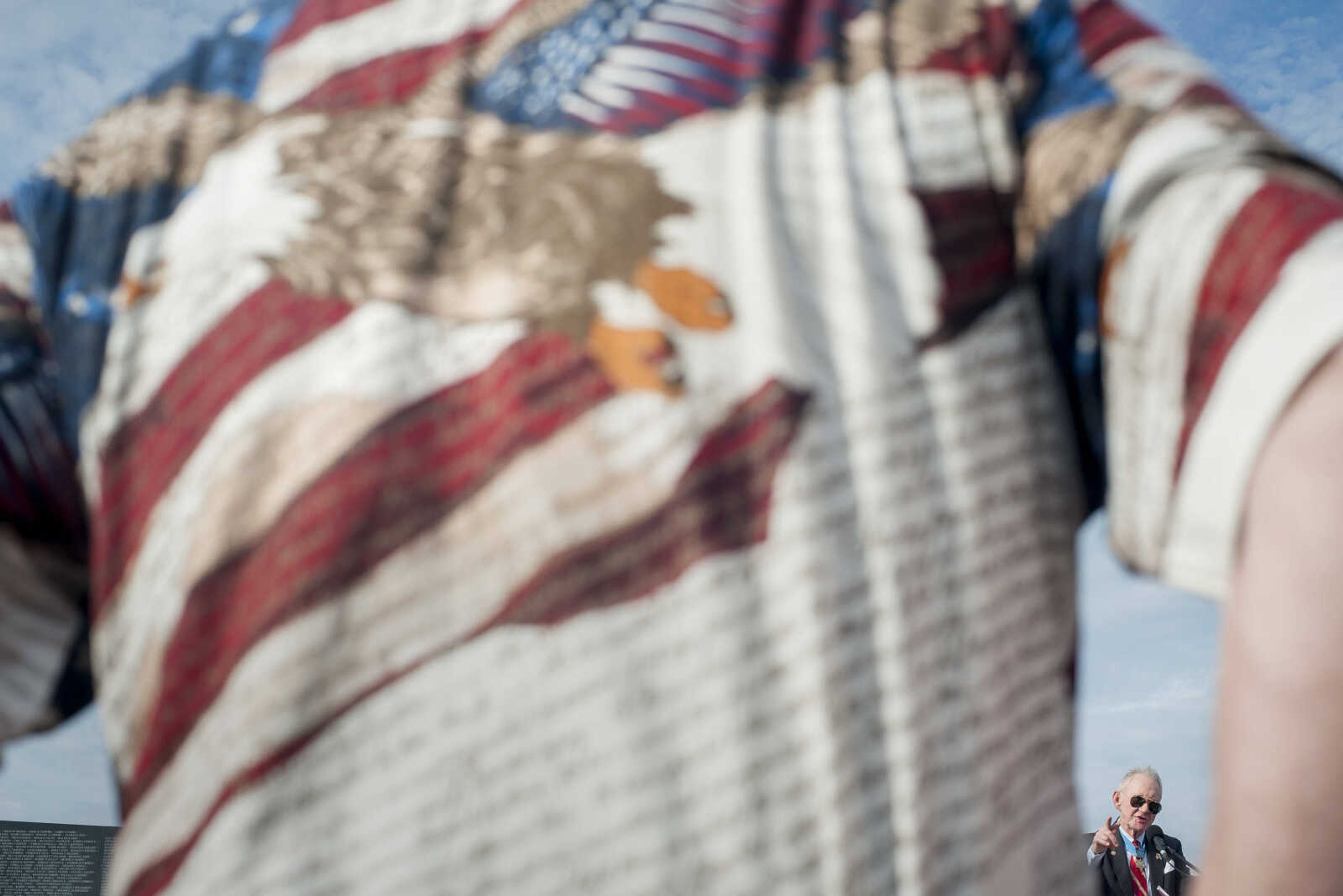 An attendee's patriotic shirt is seen while United States Marine Corps Maj. Gen. James E. Livingston (ret.), right, delivers remarks during the first-ever Missouri Vietnam Wall Run  Saturday, Sept. 21, 2019, at the Missouri's National Veterans Memorial in Perryville.