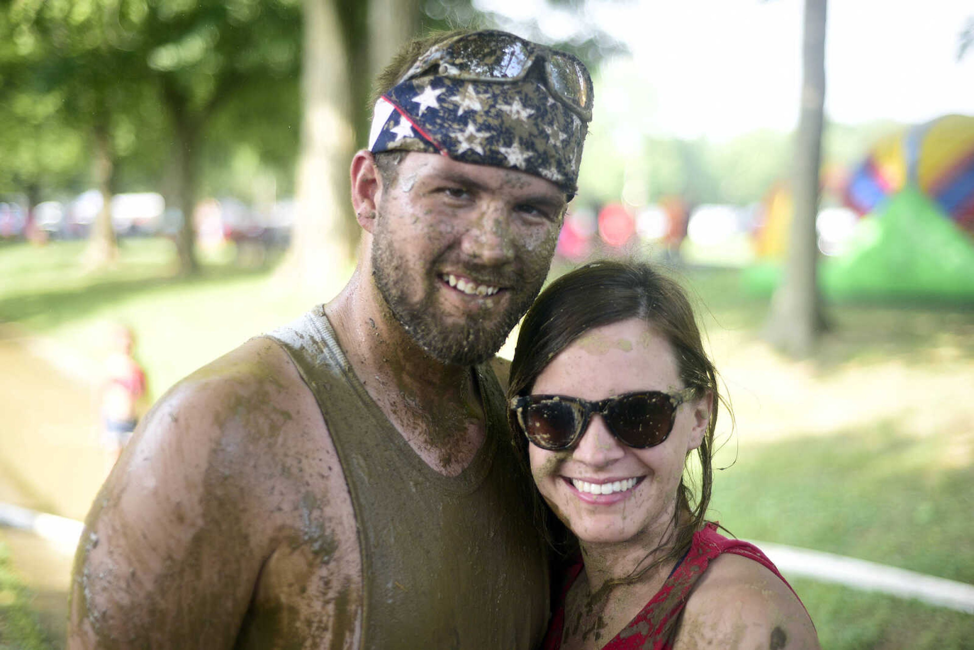 Zach and Jamie Brazer pose for a portrait after playing mud volleyball during the Fourth of July celebration on Tuesday at Jackson City Park.