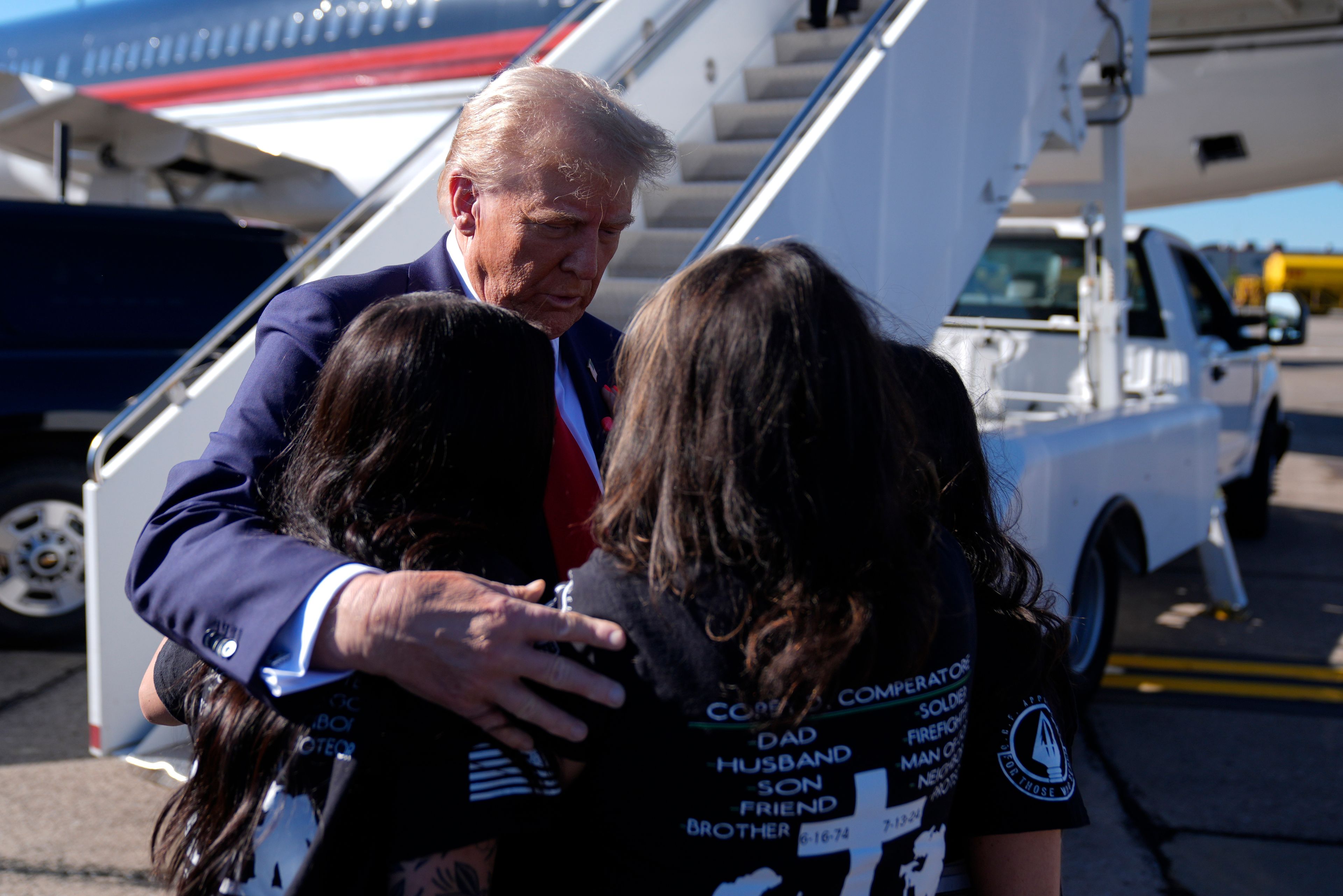 Republican presidential nominee former President Donald Trump greets family members of Corey Comperatore as he arrives at Pittsburgh International Airport en route to speak at a campaign rally at the Butler Farm Show, Saturday, Oct. 5, 2024, in Pittsburgh. (AP Photo/Evan Vucci)