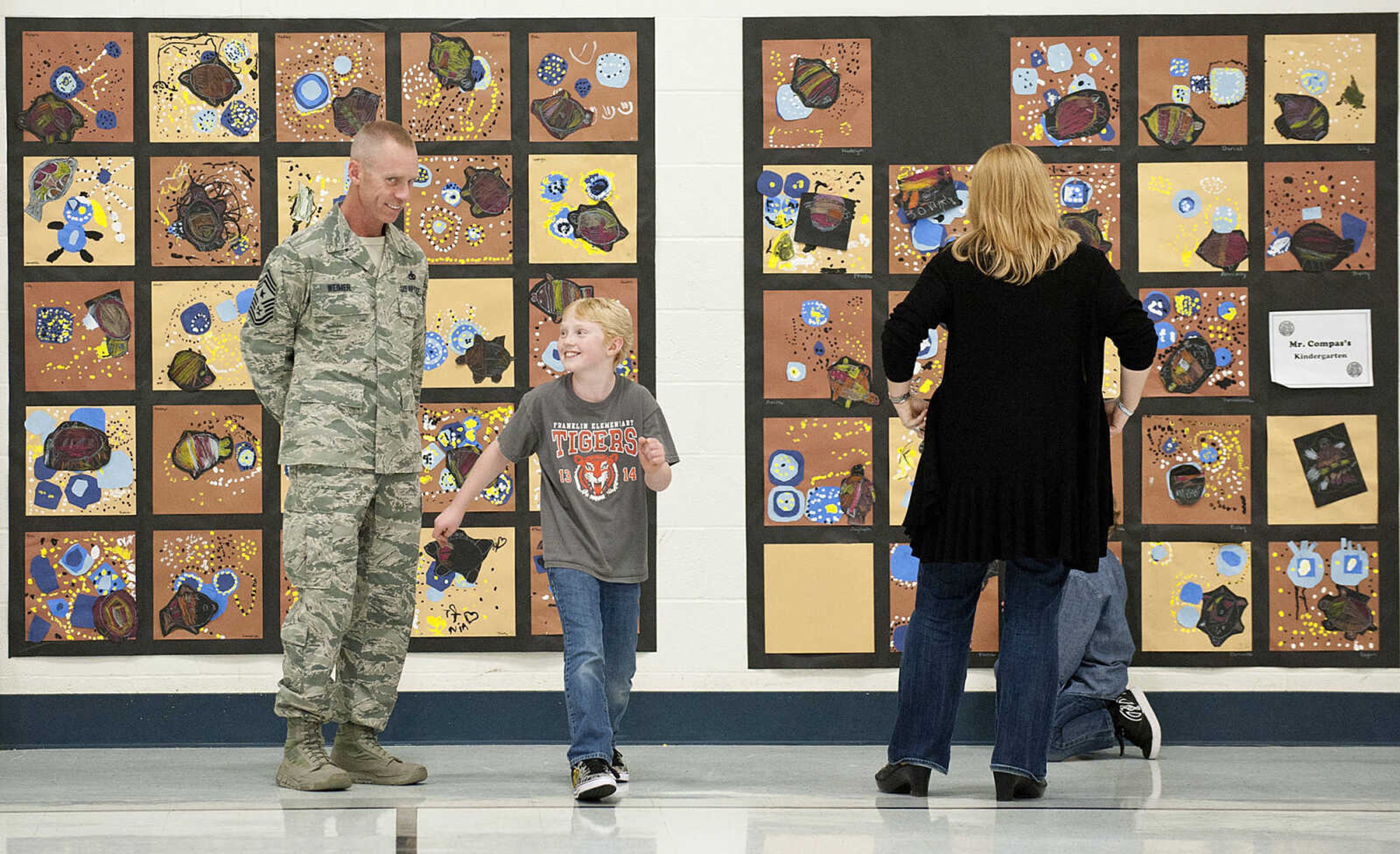 Command Chief Master Sgt. Geoff Weimer and his son Eli, 9, and wife LeAnne Friday, March 14, at Franklin Elementary School in Cape Girardeau. Sgt. Weimer is on leave from the Air Force after being deployed in the Middle East since Oct., and surprised his three sons, Geordan, 11, Eli, 9, and Gabriel, 6, in their respective classes.