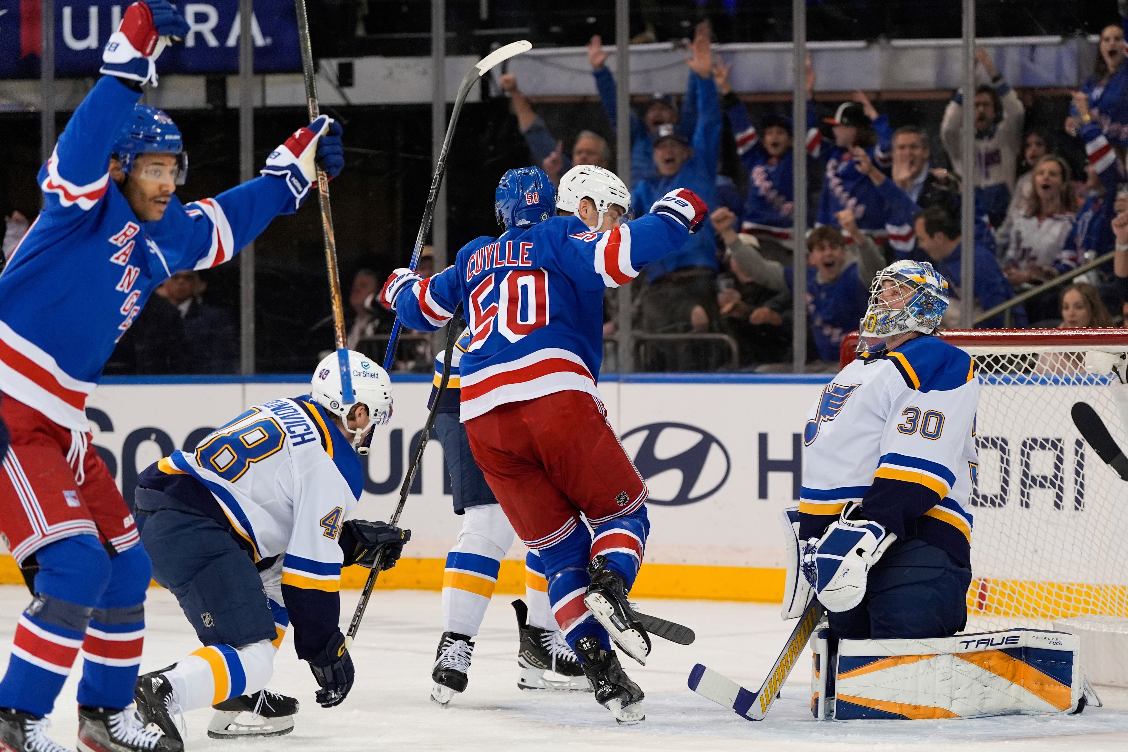 New York Rangers left wing Will Cuylle (50), center, and defenseman K'Andre Miller, left, celebrate after Cuylle scores on St. Louis Blues goaltender Joel Hofer (30), right, during the first period of an NHL hockey game, Monday, Nov. 25, 2024, in New York. (AP Photo/Julia Demaree Nikhinson)