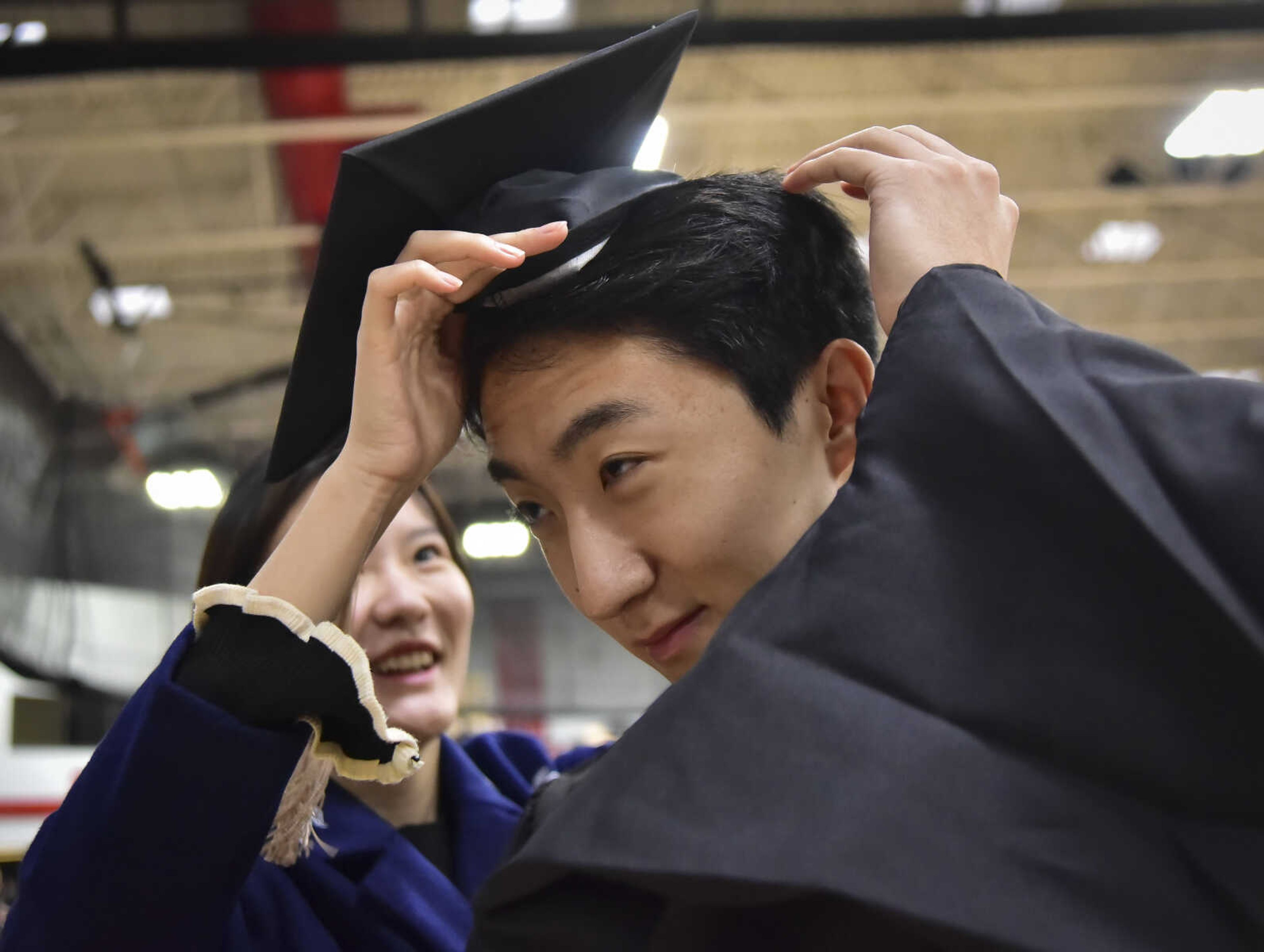 ANDREW J. WHITAKER ~ awhitaker@semissourian.com
Dong Sheng gets help by Yualiang with his cap before Southeast Missouri State University graduation Saturday, Dec. 17, 2016 at the Show Me Center in Cape Girardeau.