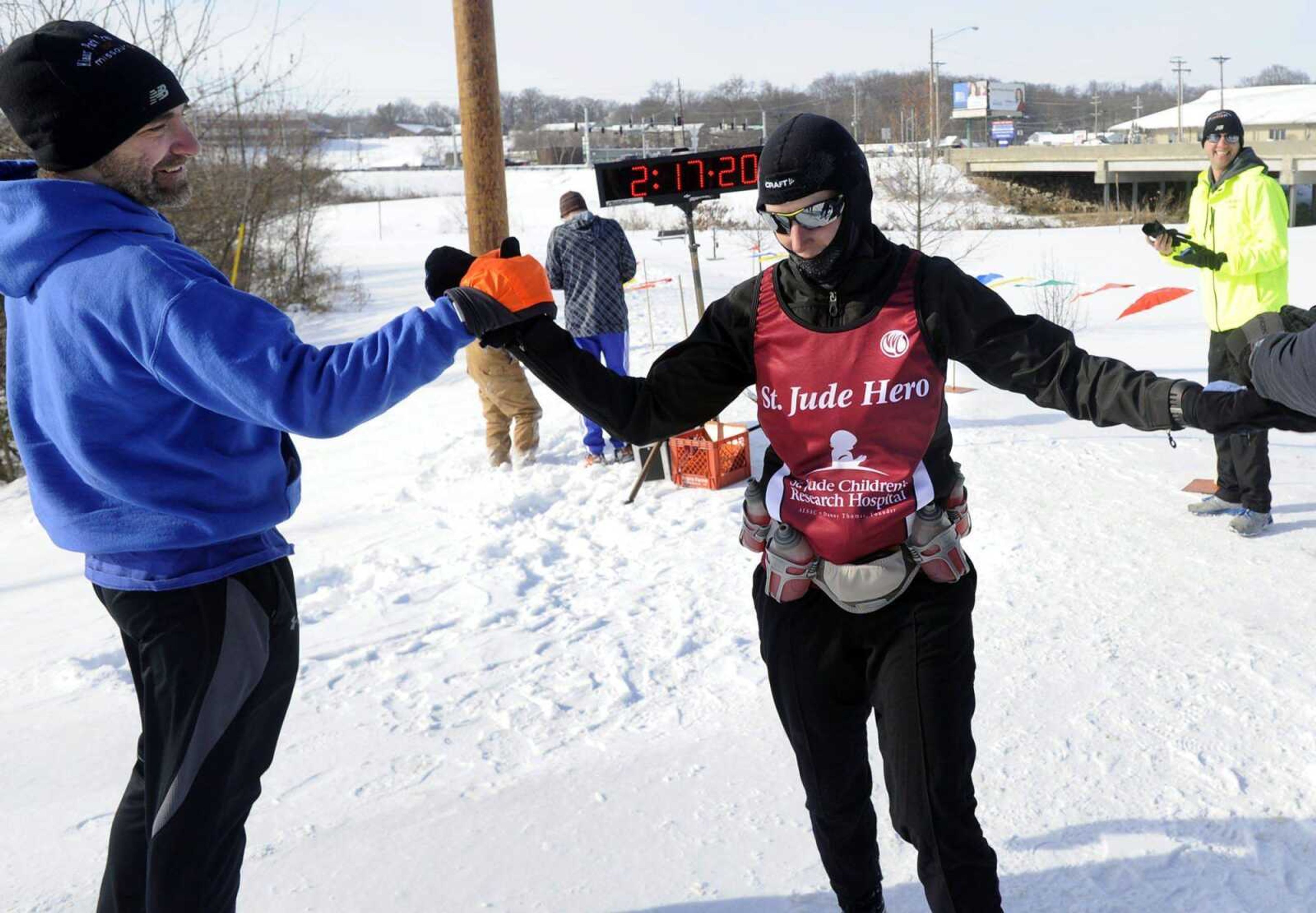 Bryan Kelpe, left, congratulates Laura Sheridan as the first female to finish the St. Jude Frostbite Half-Marathon on Saturday in Cape Girardeau. (Fred Lynch)