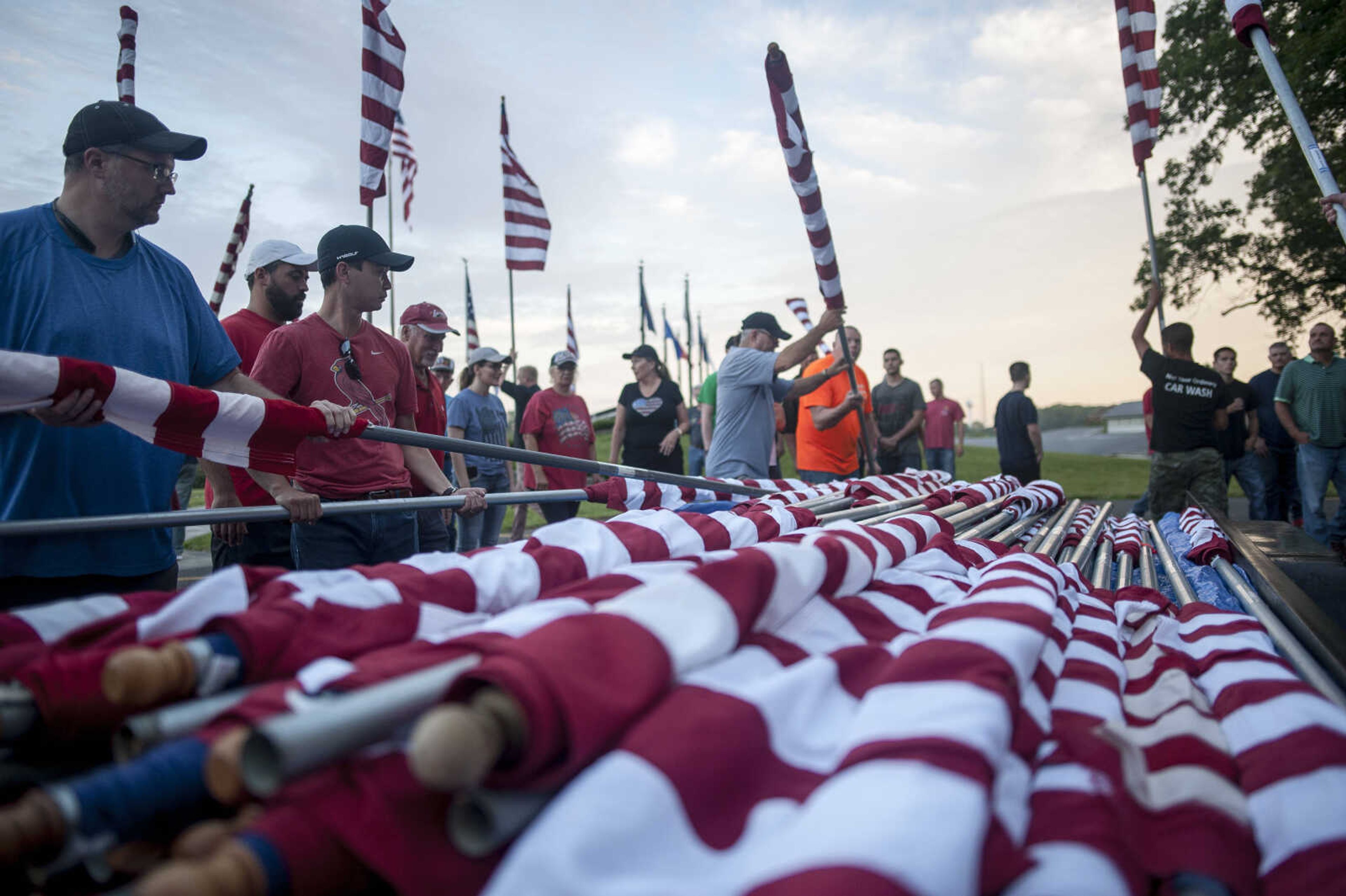 Volunteers install flags Wednesday, July 3, 2019, Avenue of Flags in Cape Girardeau County Park.