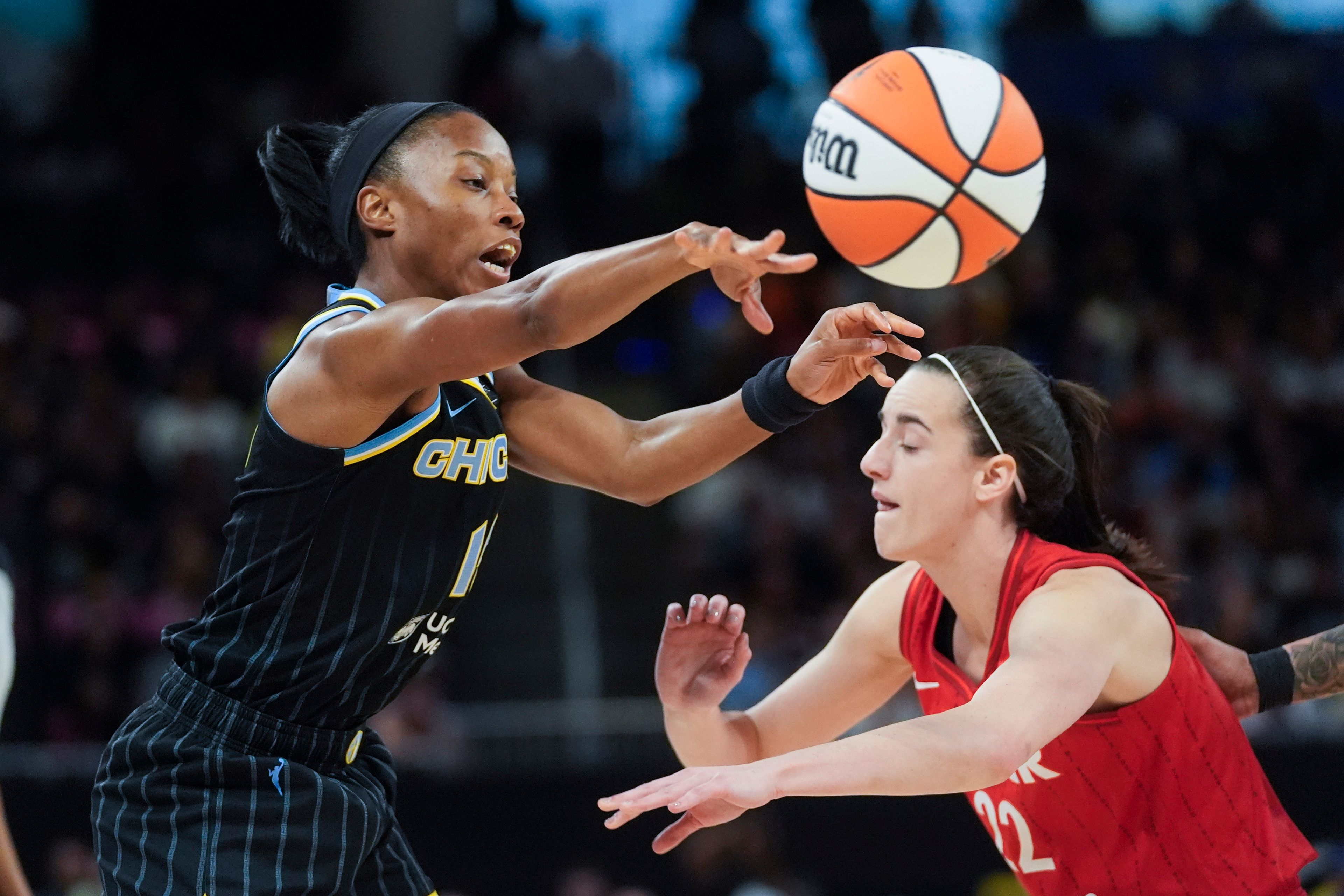 Chicago Sky guard Lindsay Allen, left, passes the ball by Indiana Fever guard Caitlin Clark during the first half of a WNBA basketball game Friday, Aug. 30, 2024, in Chicago. (AP Photo/Erin Hooley)