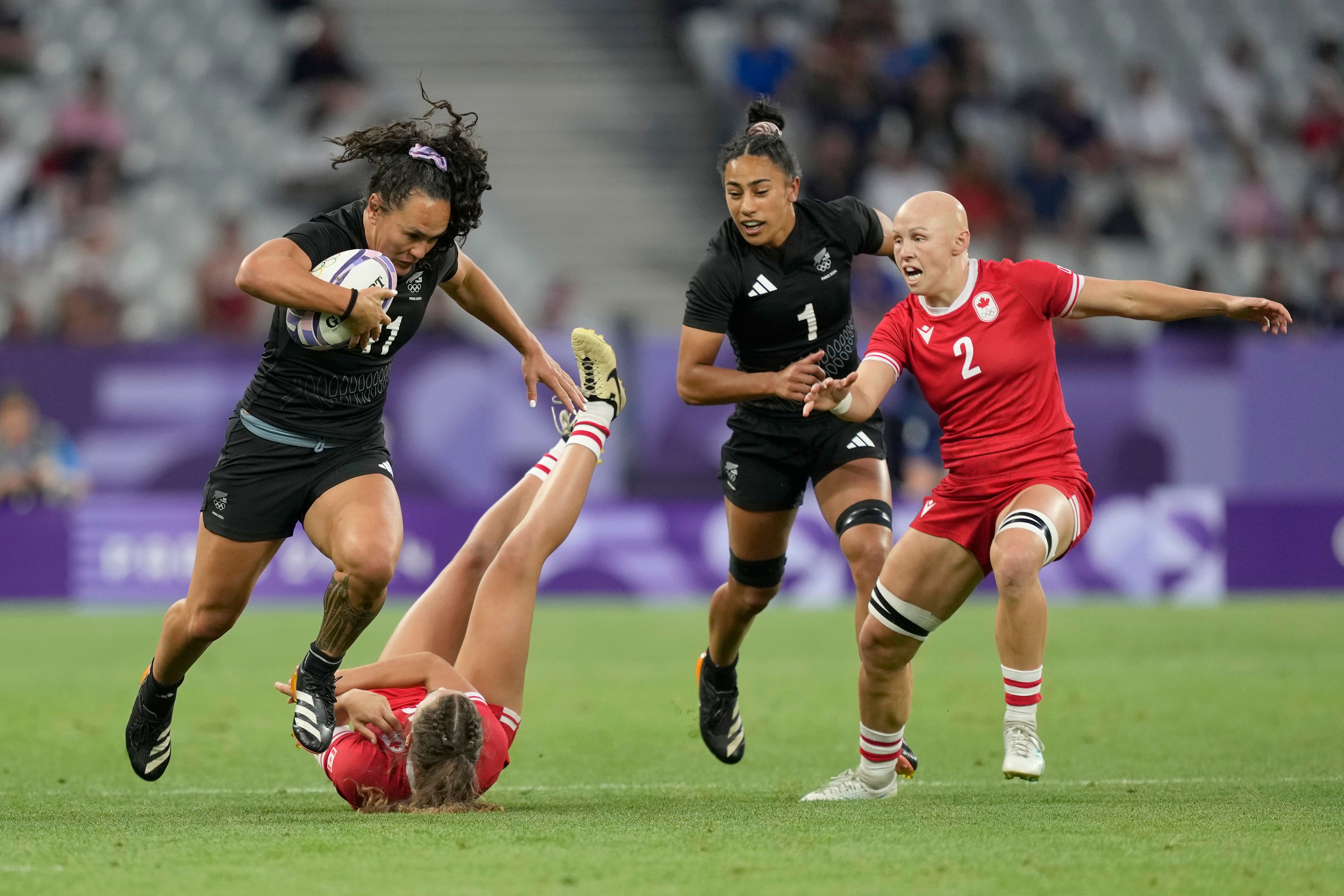 New Zealand's Portia Woodman-Wickliffe gets past the challenge of Canada's Chloe Daniels during the women's Pool A Rugby Sevens match between New Zealand and Canada at the 2024 Summer Olympics, in the Stade de France, in Saint-Denis, France, Sunday, July 28, 2024. (AP Photo/Tsvangirayi Mukwazhi)