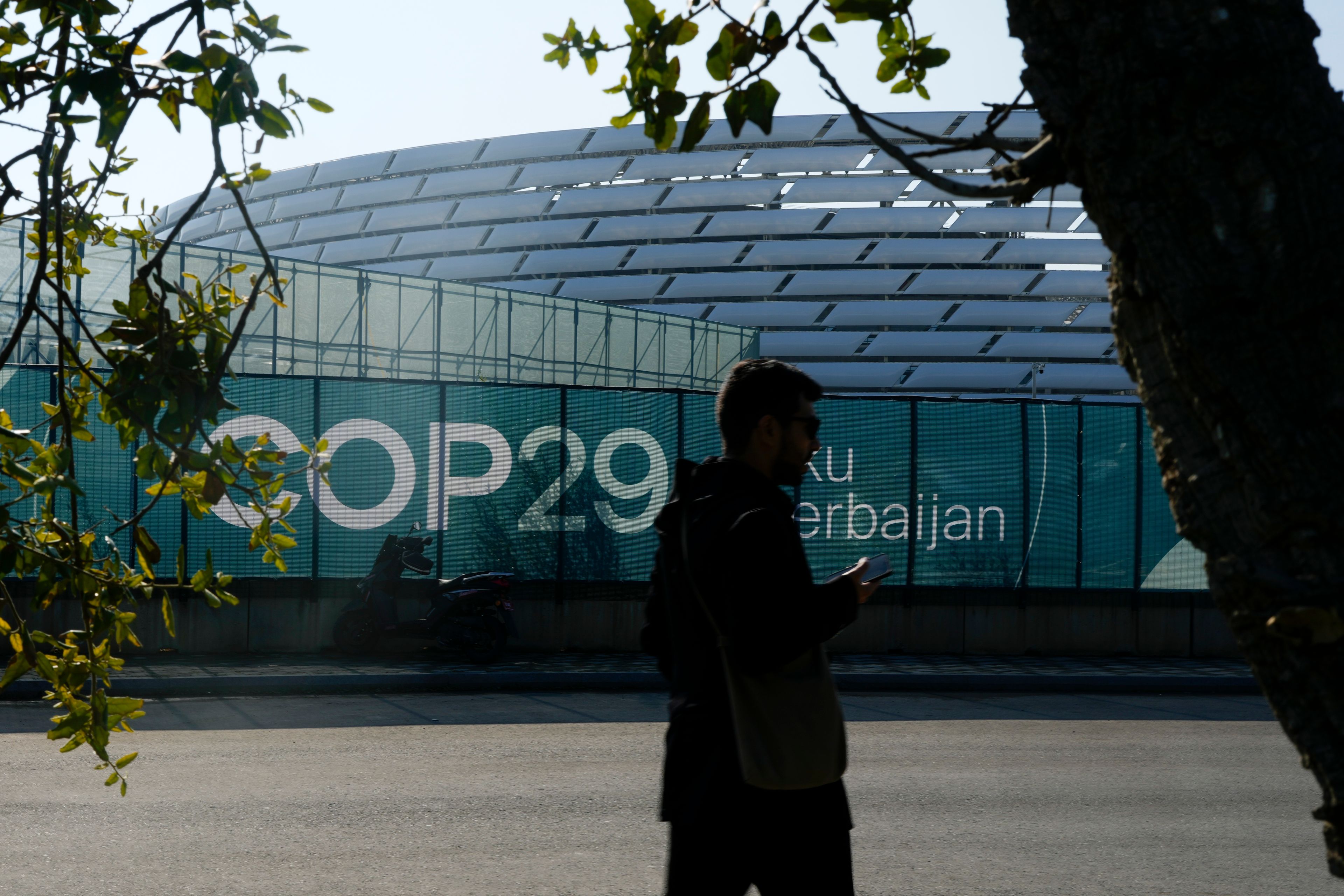 A person walks outside the Baku Olympic Stadium, the venue for the COP29 U.N. Climate Summit, Sunday, Nov. 10, 2024, in Baku, Azerbaijan. (AP Photo/Rafiq Maqbool)