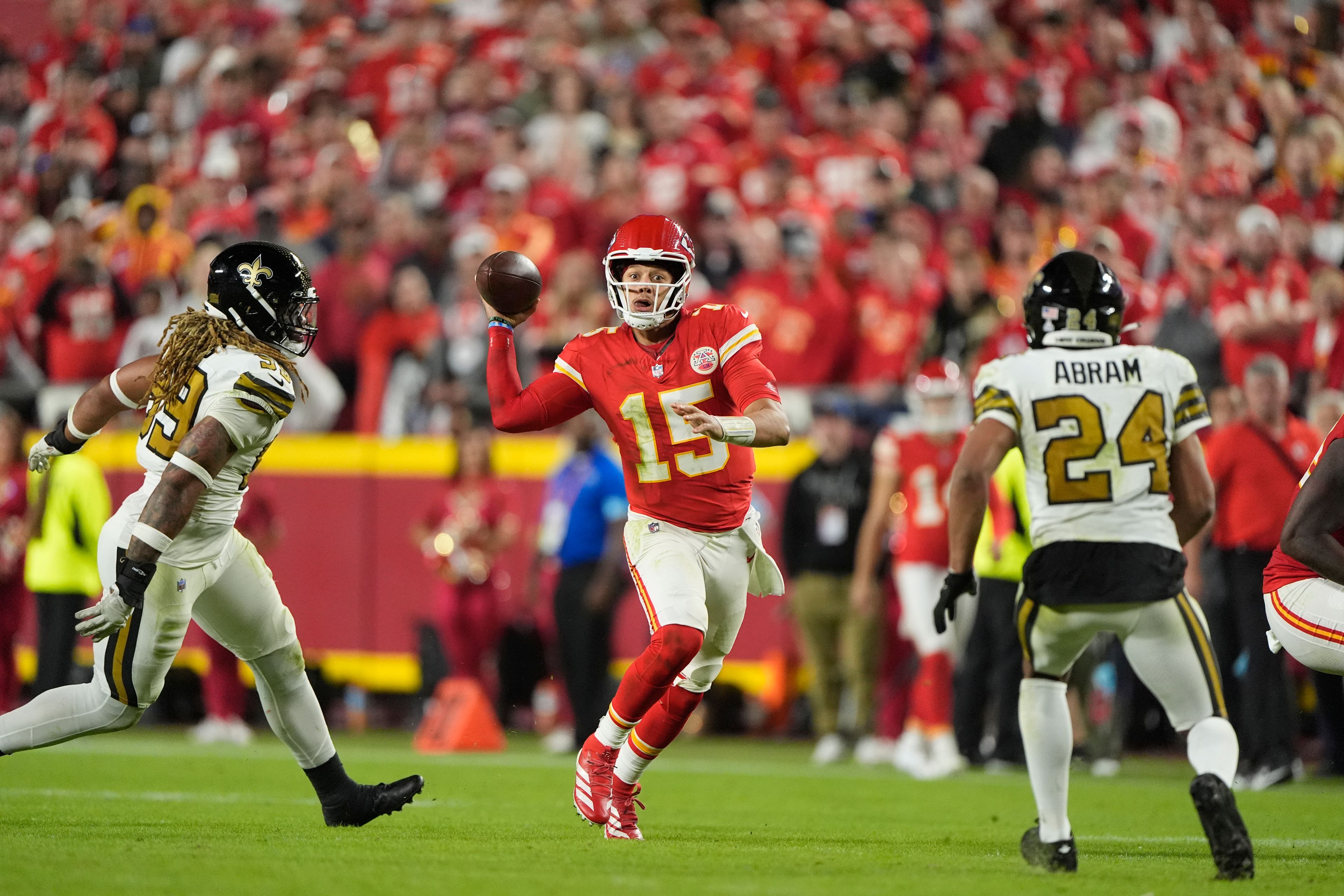 Kansas City Chiefs quarterback Patrick Mahomes, center, runs with the ball as New Orleans Saints defensive end Chase Young and safety Johnathan Abram (24) defend during the second half of an NFL football game Monday, Oct. 7, 2024, in Kansas City, Mo. (AP Photo/Charlie Riedel)