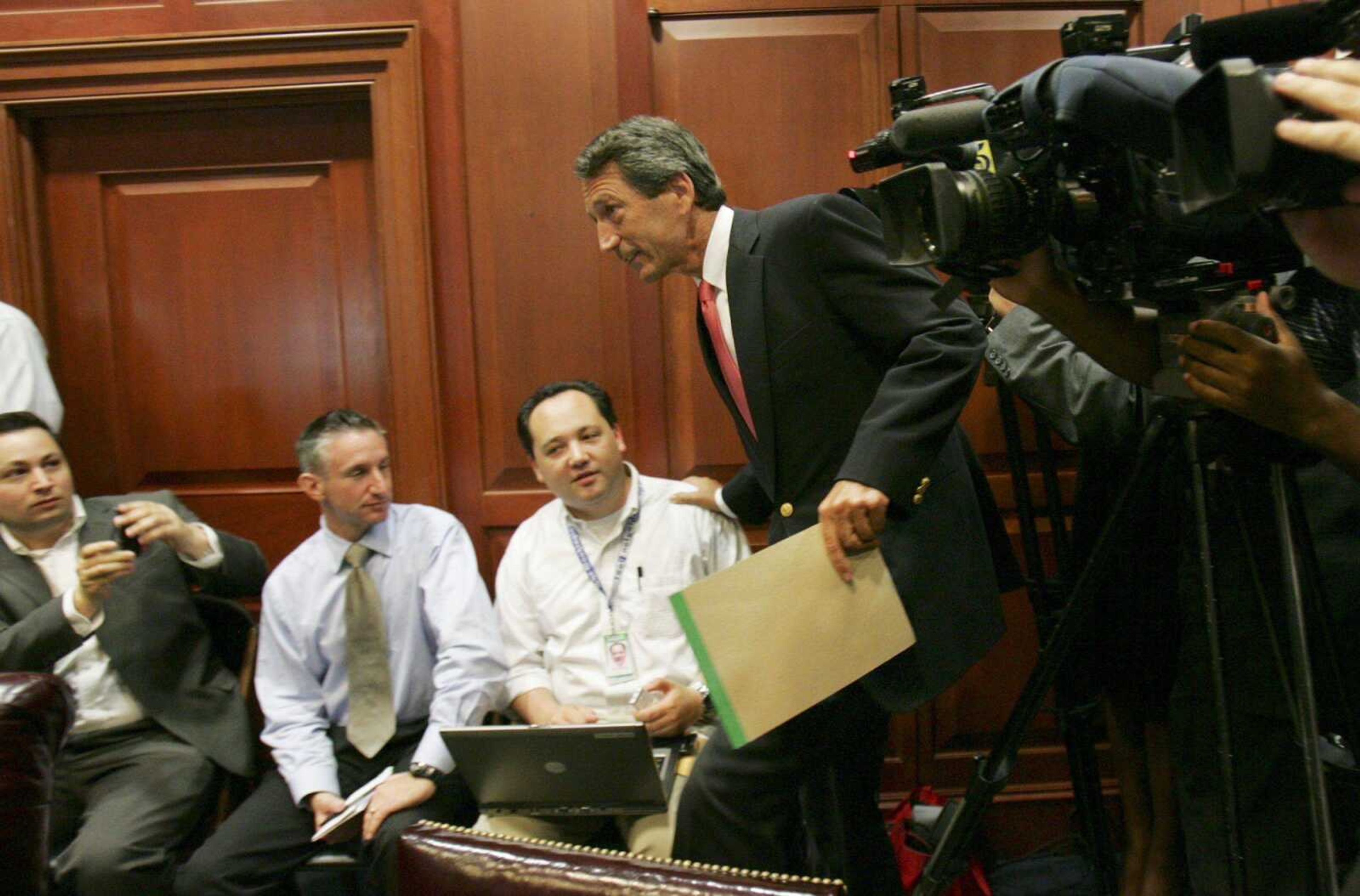 South Carolina Gov. Mark Sanford makes his way through the video cameras and reporters for the start of his cabinet meeting Friday in Columbia, S.C., where he apologized to his state agency chiefs for keeping them in the dark when he went to Argentina to see his mistress. (Mary Ann Chastain ~ Associated Press)