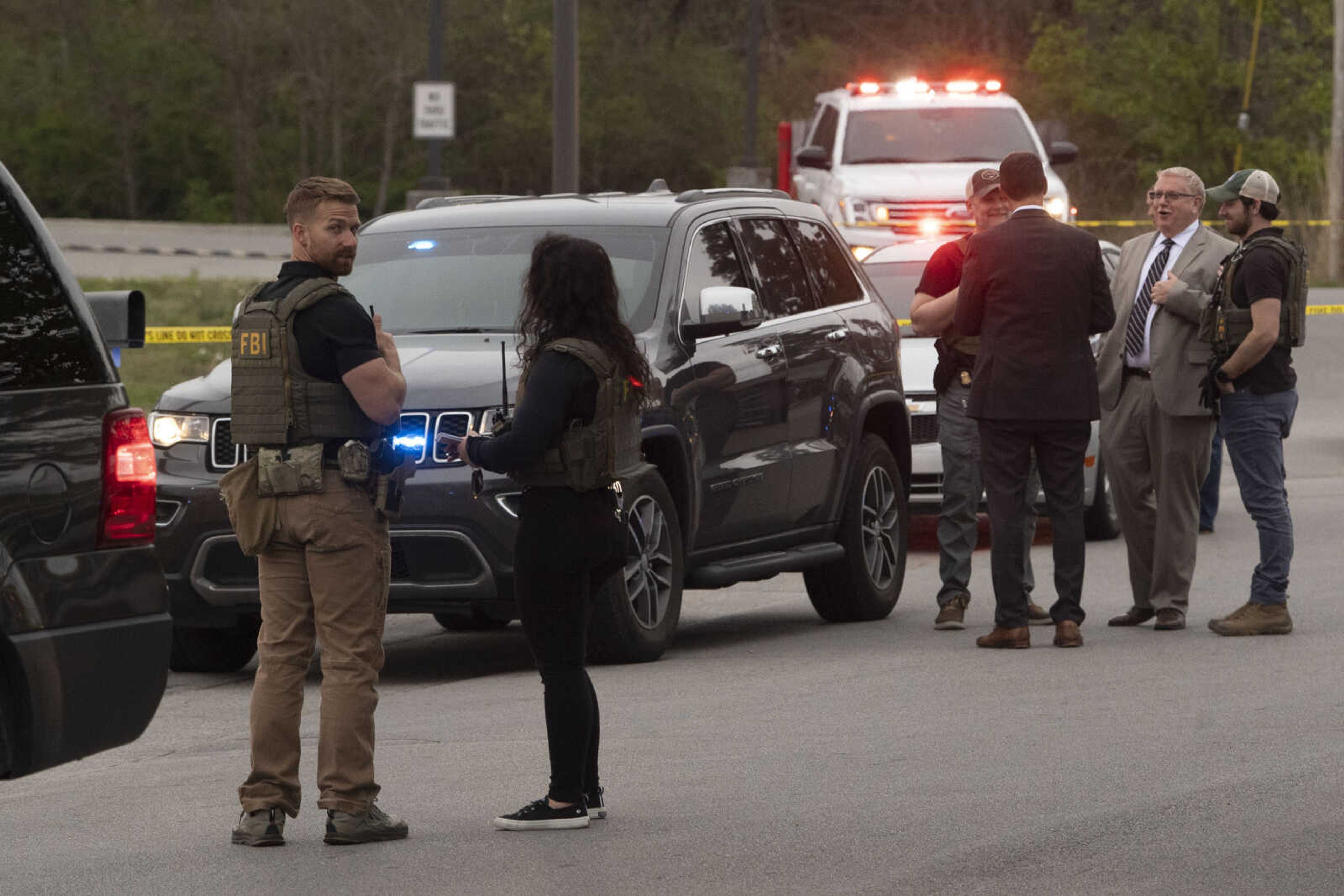 Knox County Sheriff's Office and FBI agents work in a parking lot area Monday in Knoxville, Tennessee. A lawyer for a former Maryland political aide says the man has died after being wounded while being confronted by law enforcement agents following a manhunt launched after he failed to appear for trial. Attorney Joseph Murtha said it is not immediately clear whether Roy McGrath's wound was self-inflicted or came during an exchange of gunfire with agents.